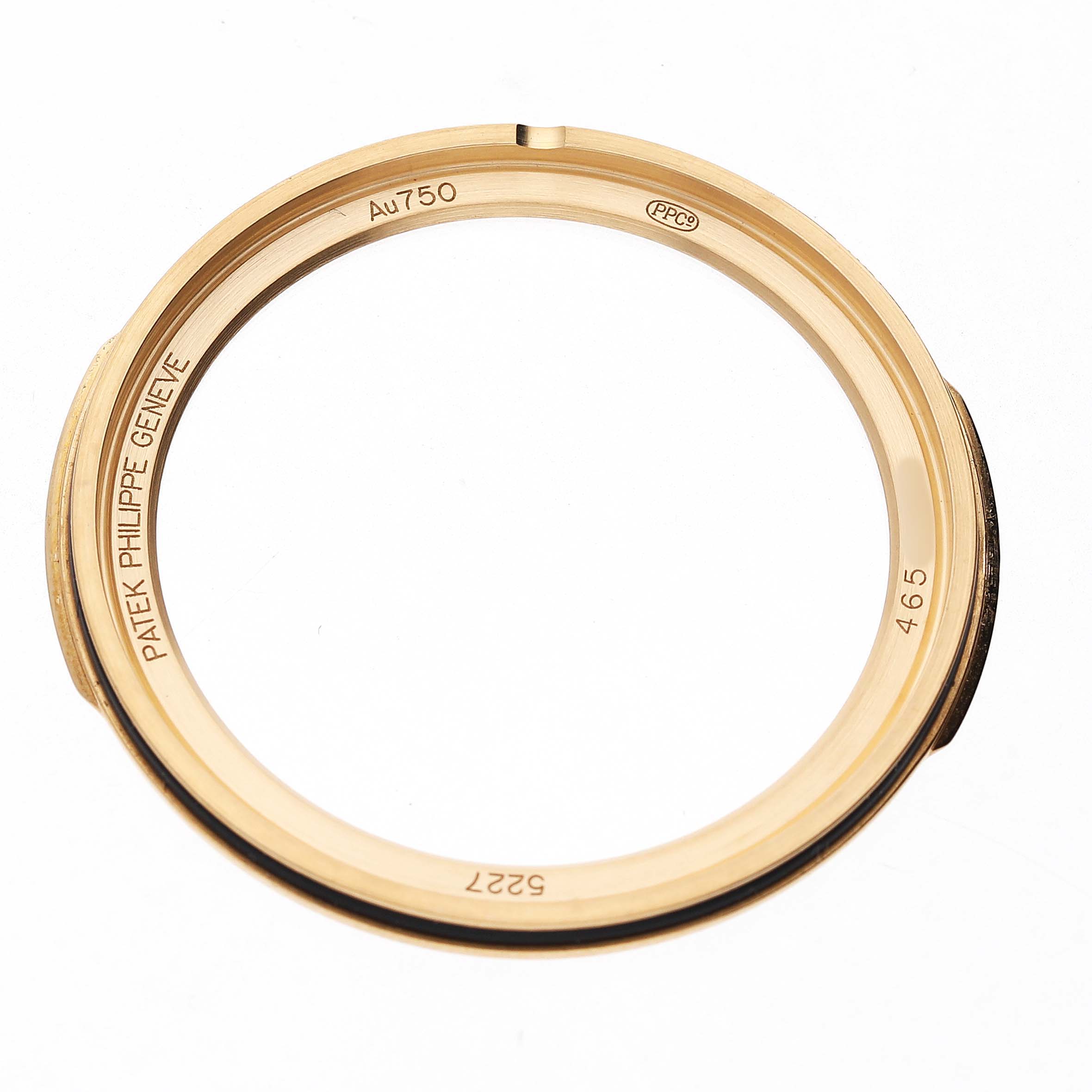 The image shows the gold bezel ring of a Patek Philippe Calatrava 5227J Men's Yellow Gold White Dial watch from a top view angle.