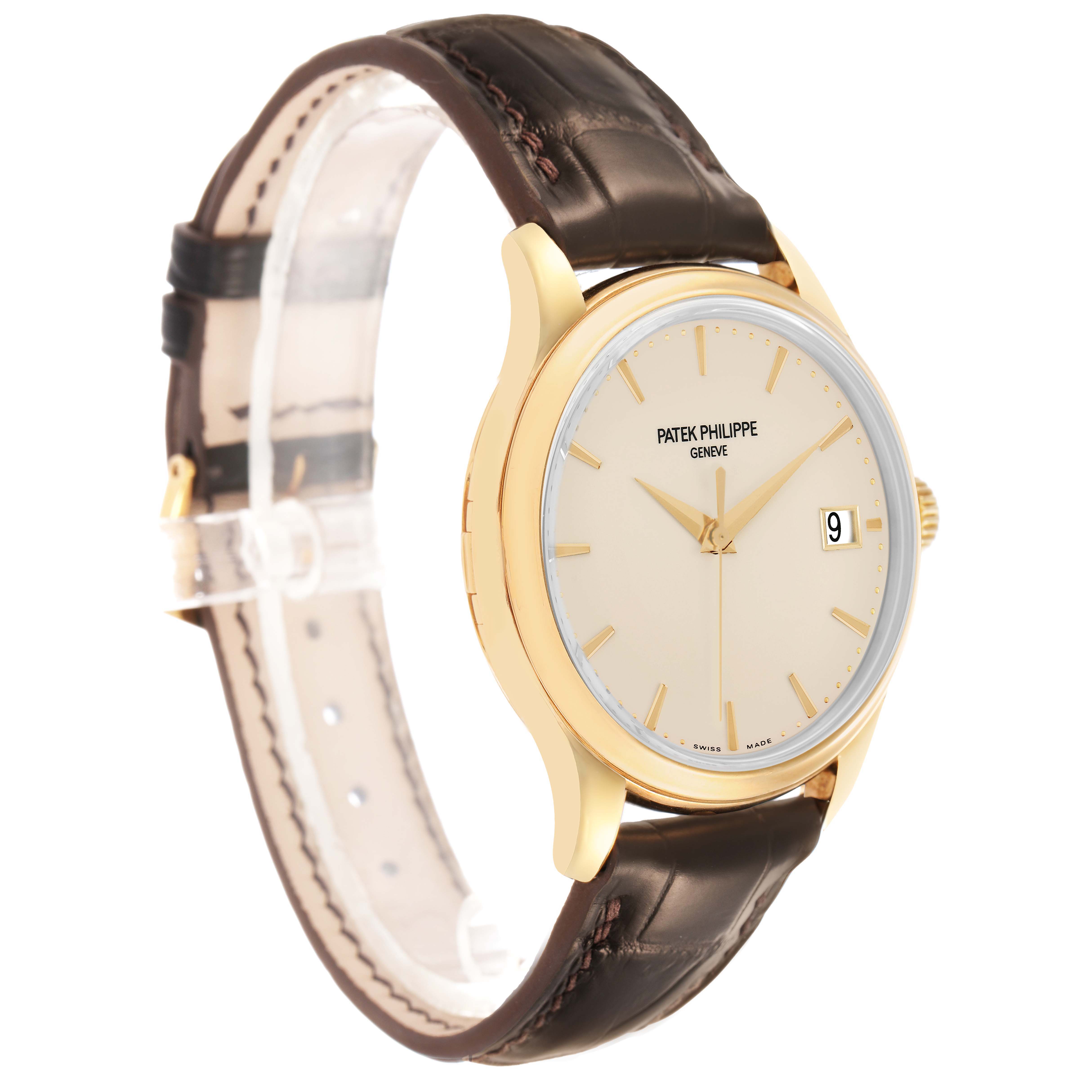 The Patek Philippe Calatrava 5227J Men's Yellow Gold White Dial watch is shown at a three-quarter angle, displaying the face, date, and leather strap.