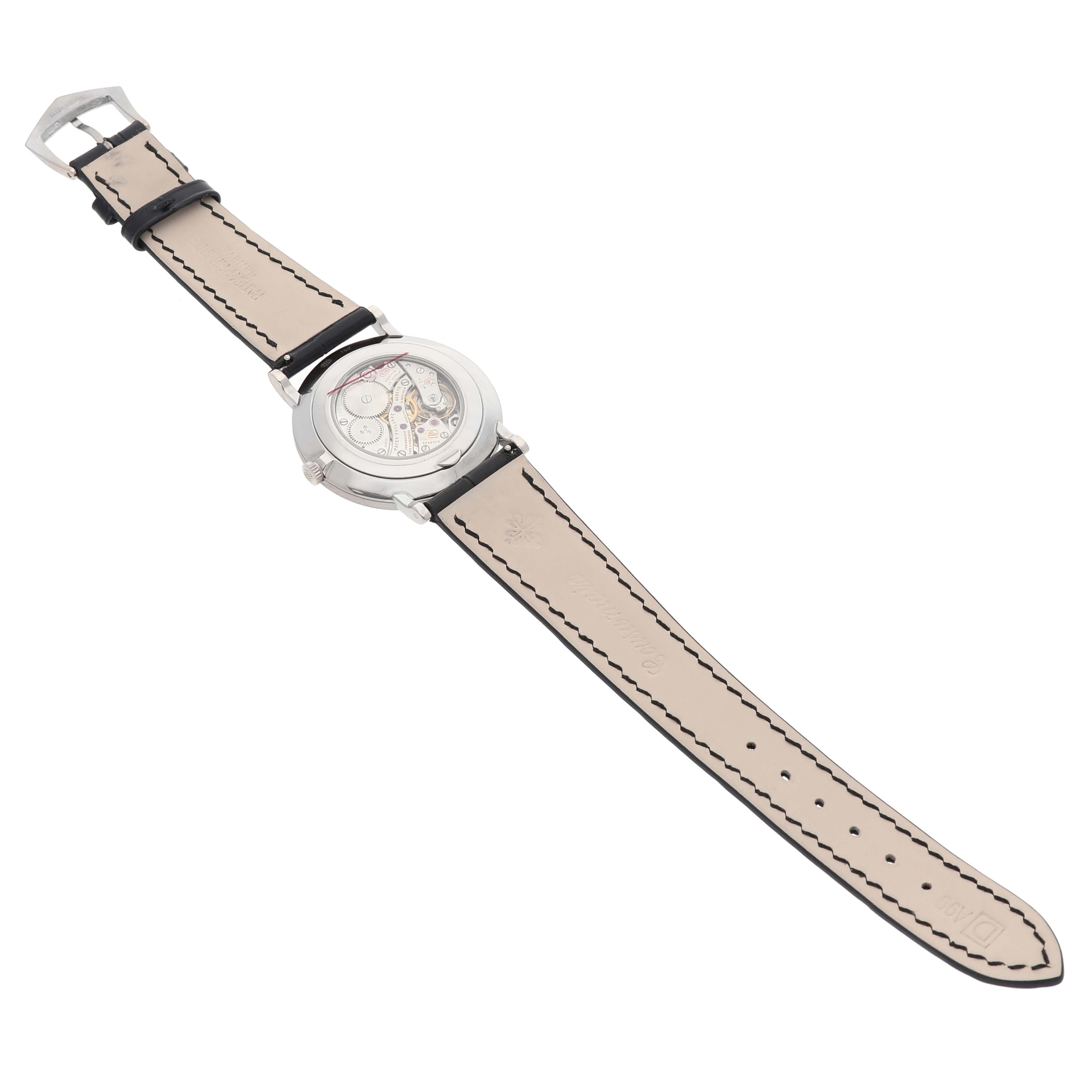 The Patek Philippe Calatrava 5116G Men's White Gold White Dial watch is shown from the back, displaying its open case back and leather strap.