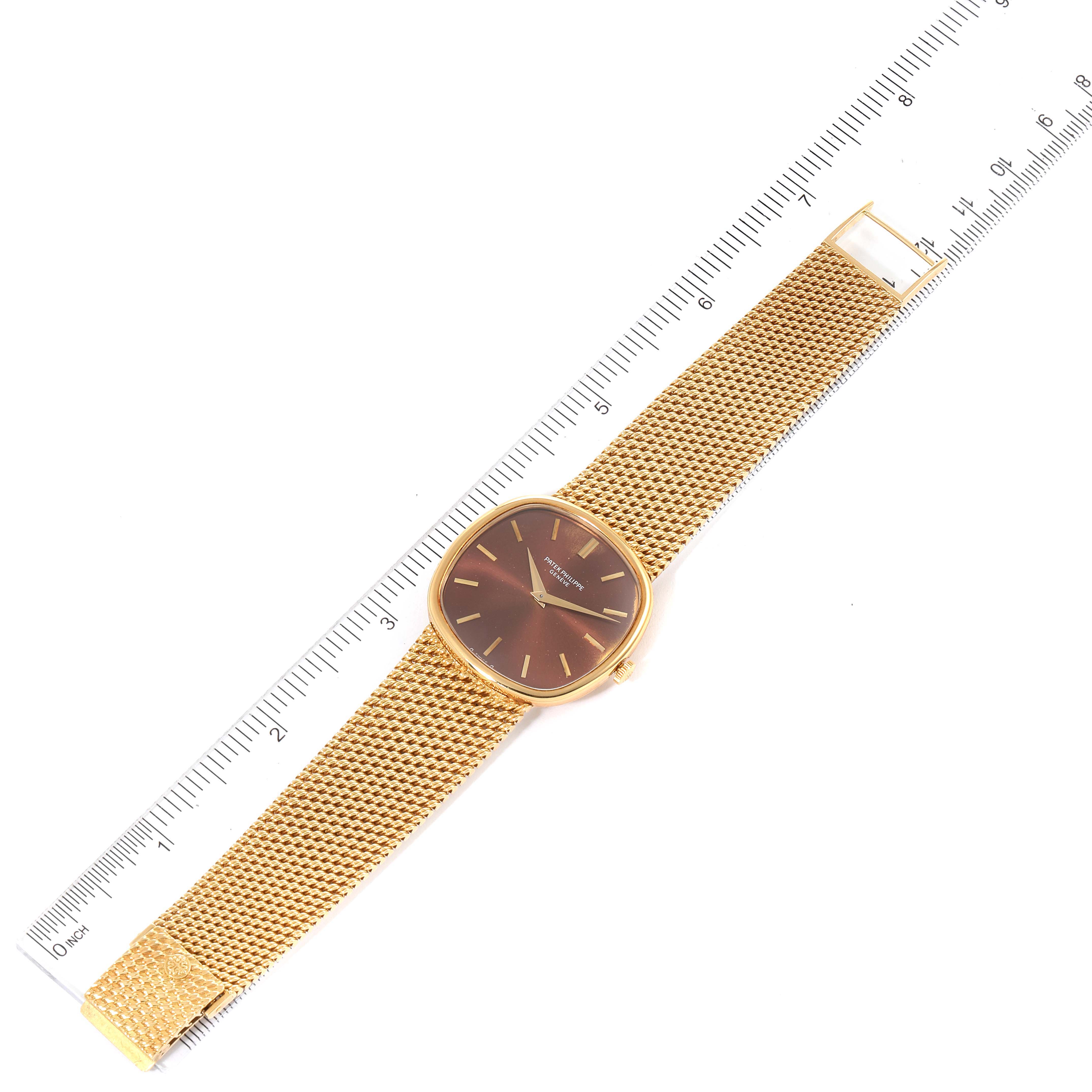 The image shows the Patek Philippe 3844 Men's Yellow Gold Brown Dial 3844 Men's Yellow Gold Brown Dial Ellipse 18k Yellow Gold Reddish Brown Dial Watch 3844 Papers model laid flat with a ruler for scale.