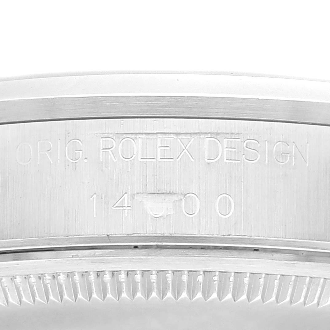 This image shows a close-up of the engraved bezel of a Rolex Air-King 14000 Men's Stainless Steel Blue Dial 14000 Men's Stainless Steel Blue Dial watch, featuring the text "ORIG. ROLEX DESIGN 14000".