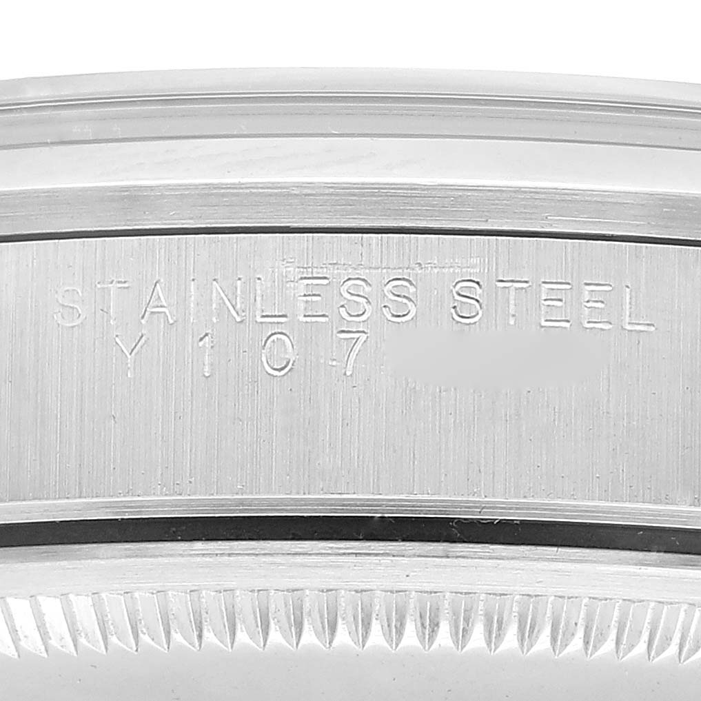 This close-up image of the Rolex Air-King 14000 Men's Stainless Steel Red Dial 14000 Men's Stainless Steel Red Dial watch shows the engraved "STAINLESS STEEL" text on its bezel.