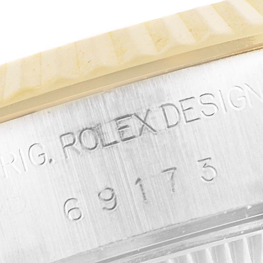 The image shows a close-up view of the engraved side of the Rolex Datejust 69173 Women's Steel and Gold (two tone) Blue Dial 69173 Women's Steel and Gold (two tone) Blue Dial watch case and part of the fluted bezel.