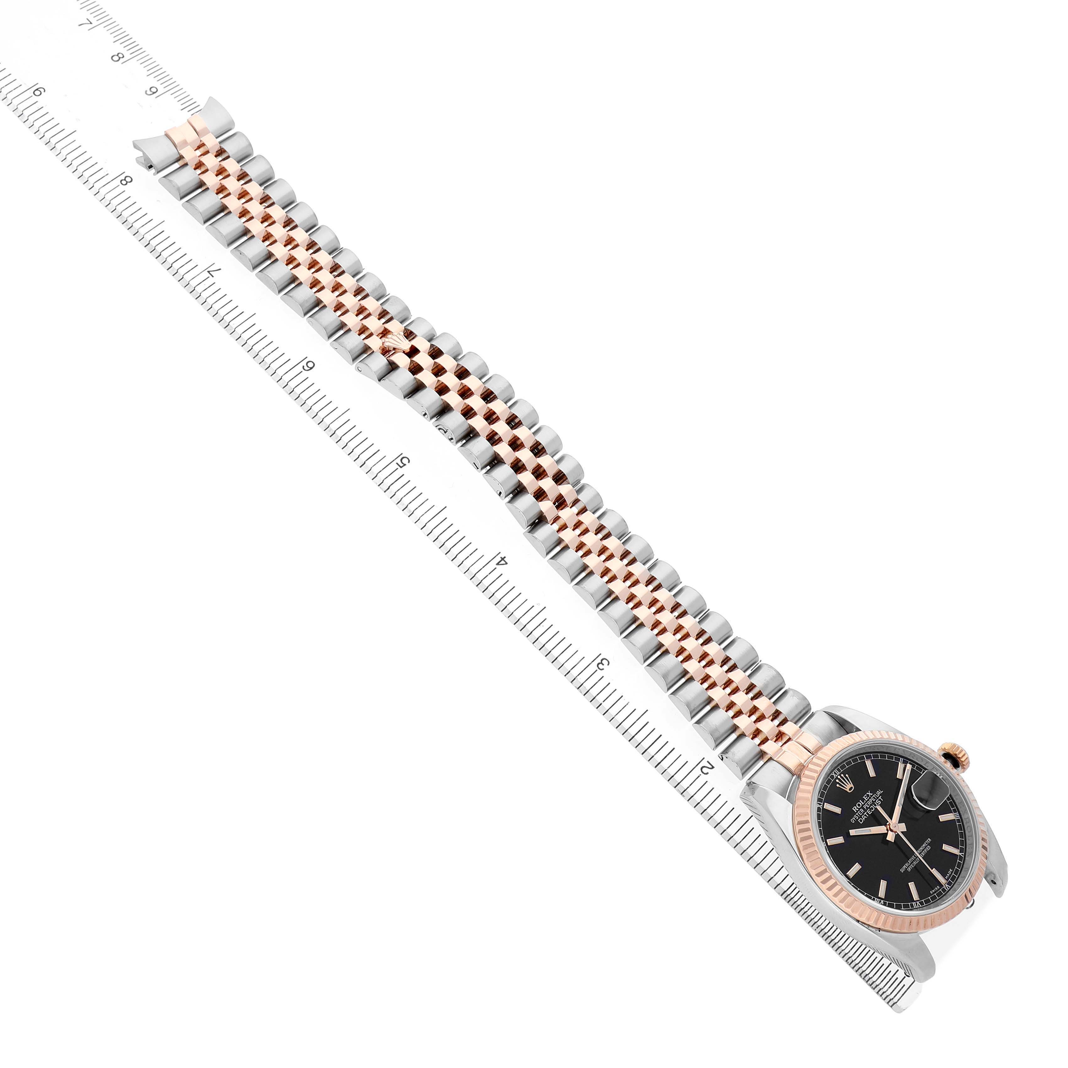 The Rolex Datejust 116231 Men's Steel and Gold (two tone) Black Dial is shown diagonally from above, highlighting the watch face, bezel, and two-tone jubilee bracelet alongside a ruler.