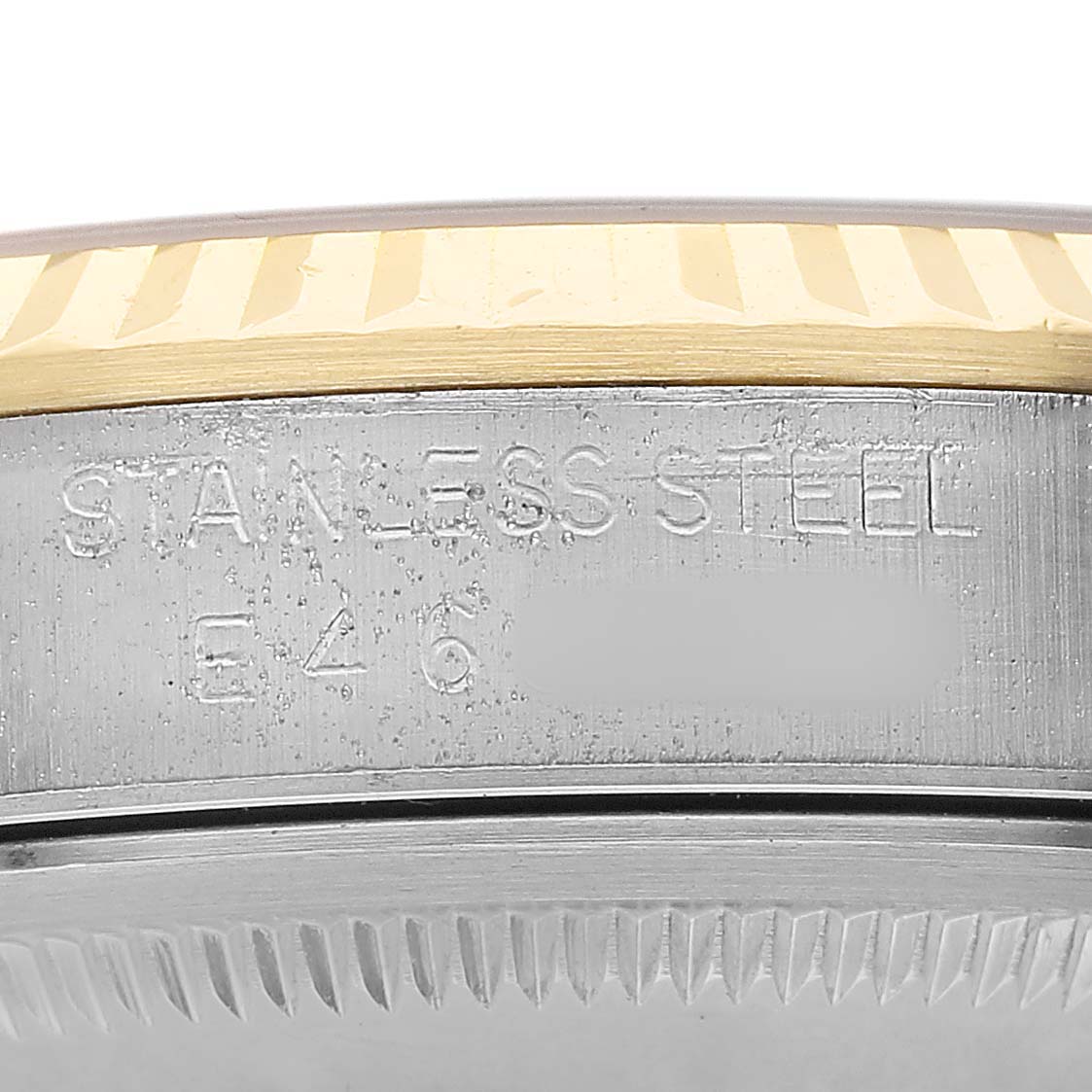 The image shows a close-up of the side engravings on a Rolex Datejust 16233 Men's Steel and Gold (two tone) White Dial watch, highlighting the stainless steel marking and part of the bezel.