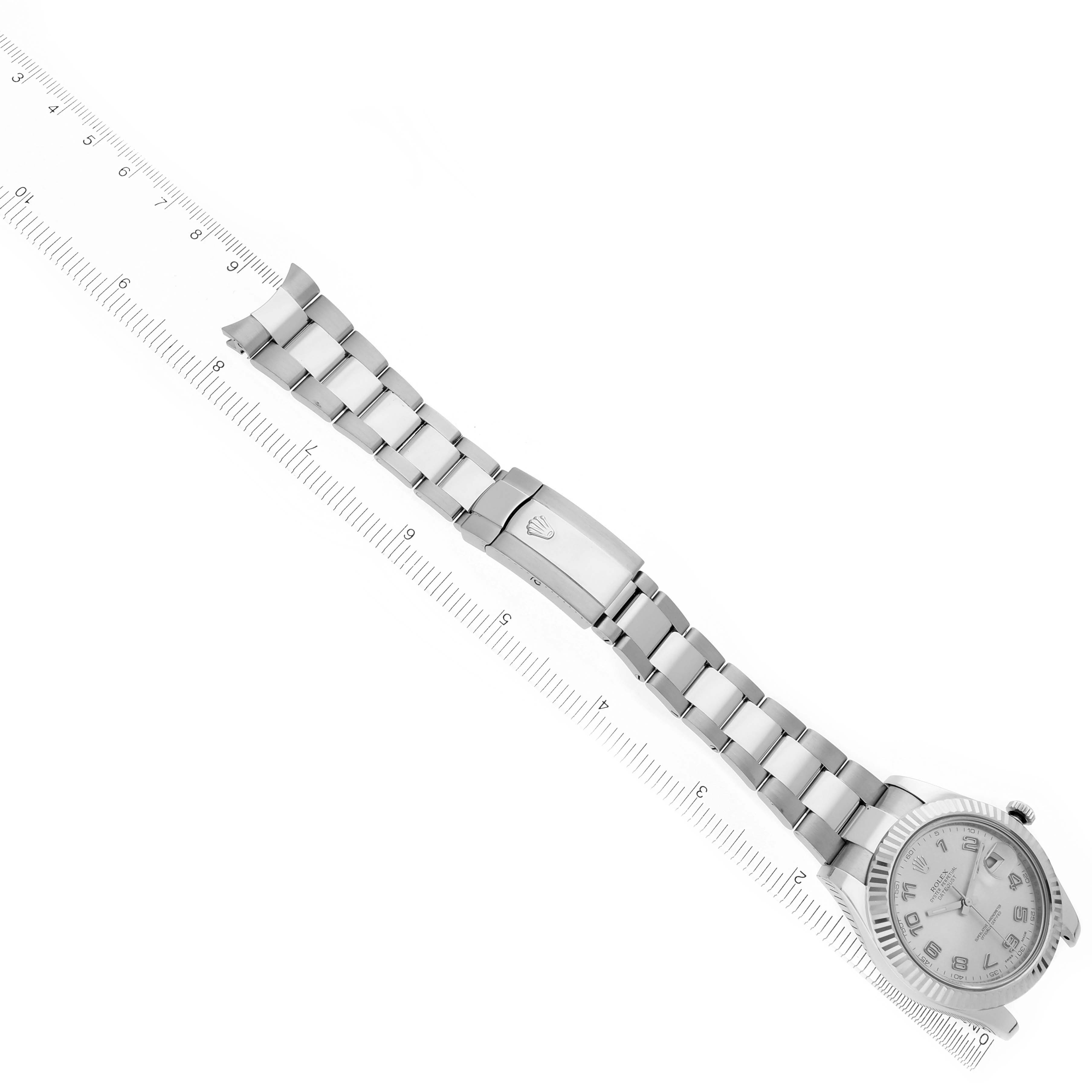 The Rolex Datejust 41, model 116334, is shown from an angled top view displaying the bracelet, clasp, and partially visible dial against a ruler backdrop.