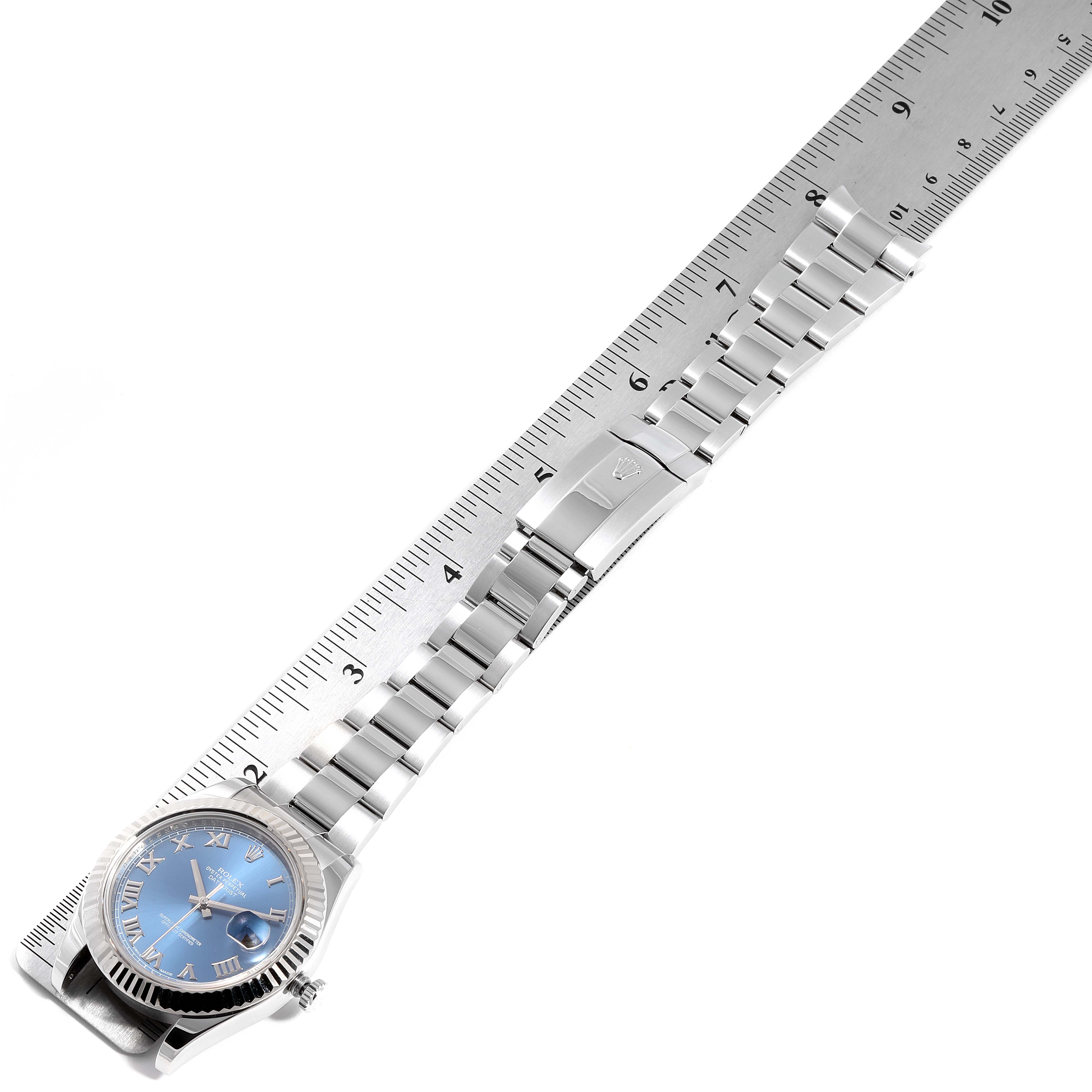 The Datejust 41 by Rolex is shown from a top view, including the watch face, bracelet, and clasp, aligned with a ruler.