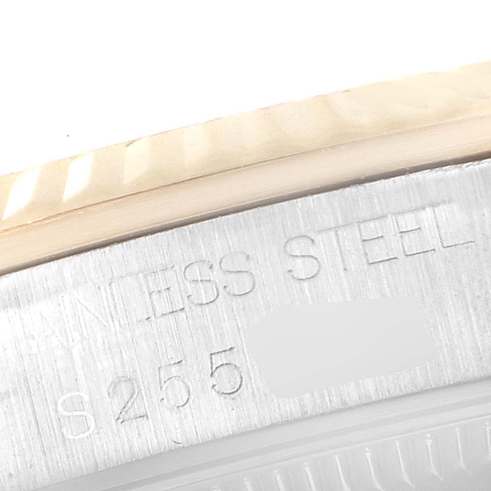 This close-up of the mid-size Rolex watch shows the edge of the case and part of the metal bezel with "STAINLESS STEEL" engraved.