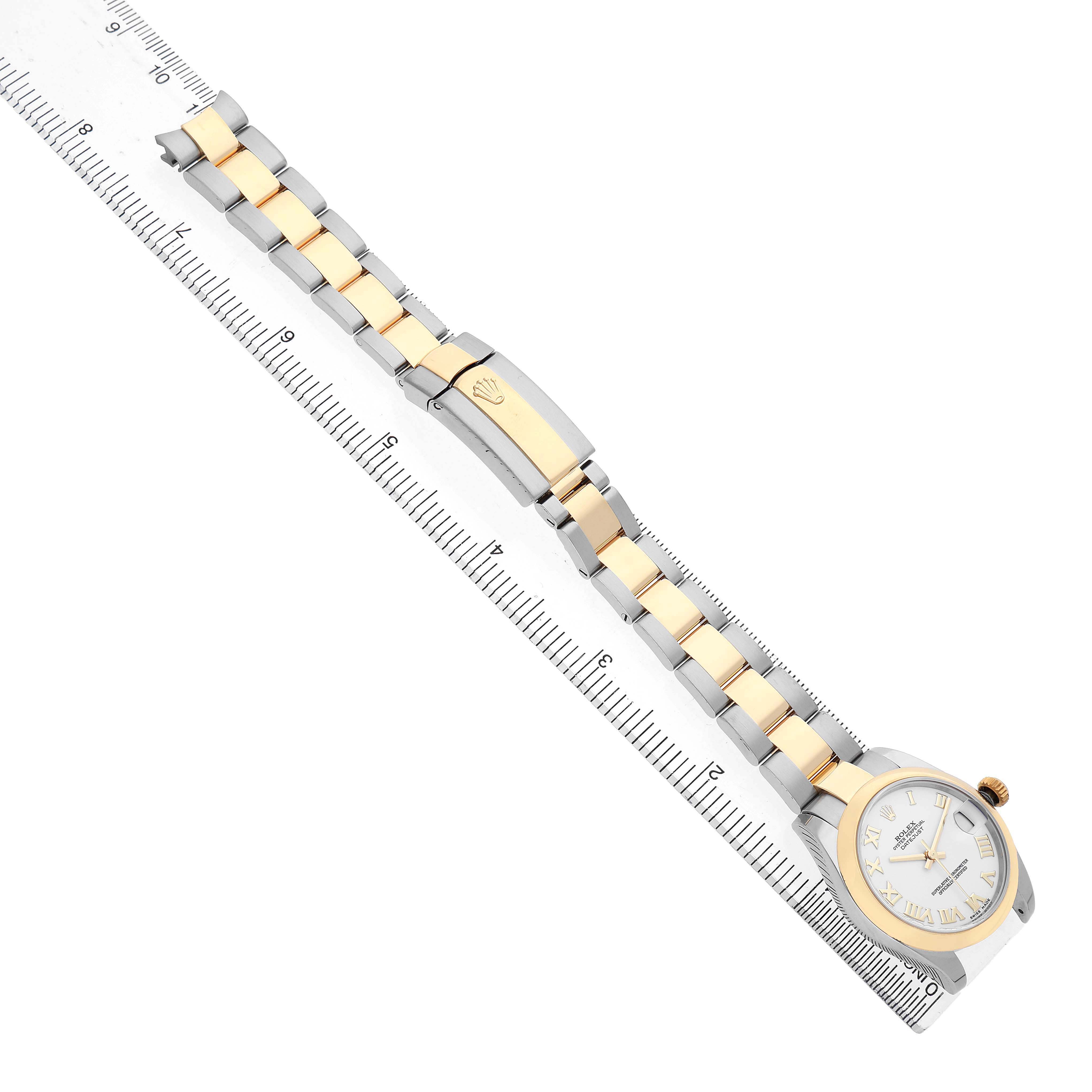 The Rolex Mid-Size 178243 Women's Stainless Steel White Dial watch is shown from a diagonal top view, featuring the face, bracelet, and clasp aligned with a ruler.