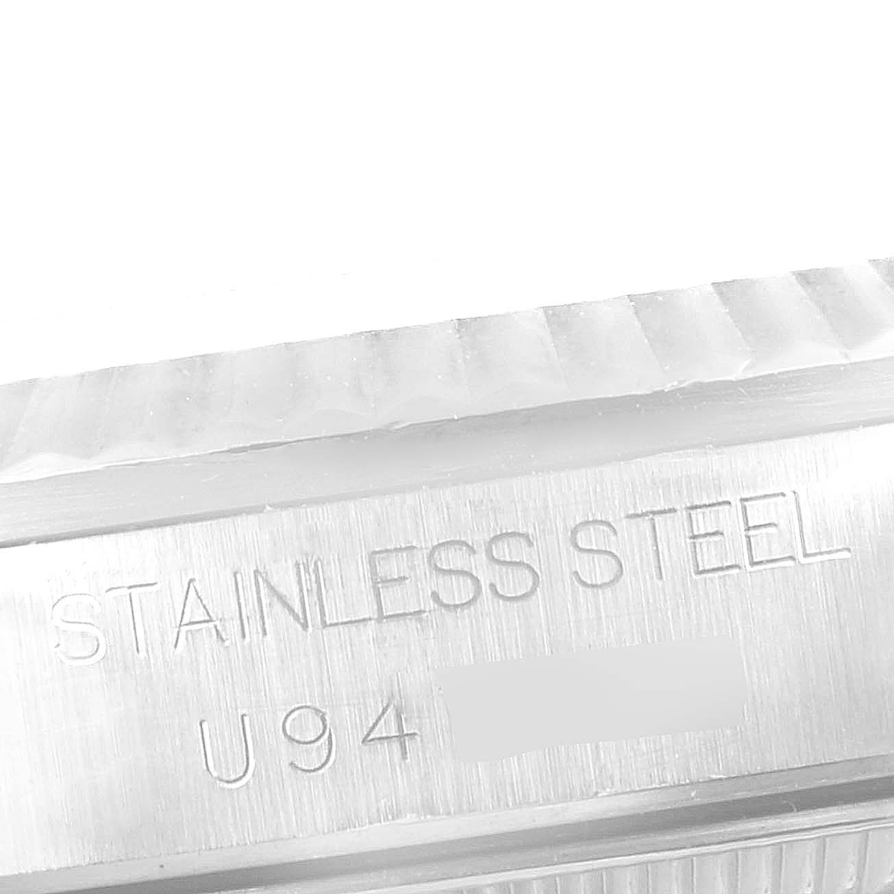 The image shows a close-up angle of the side of a Mid-Size Rolex watch, highlighting the "STAINLESS STEEL" engraving.