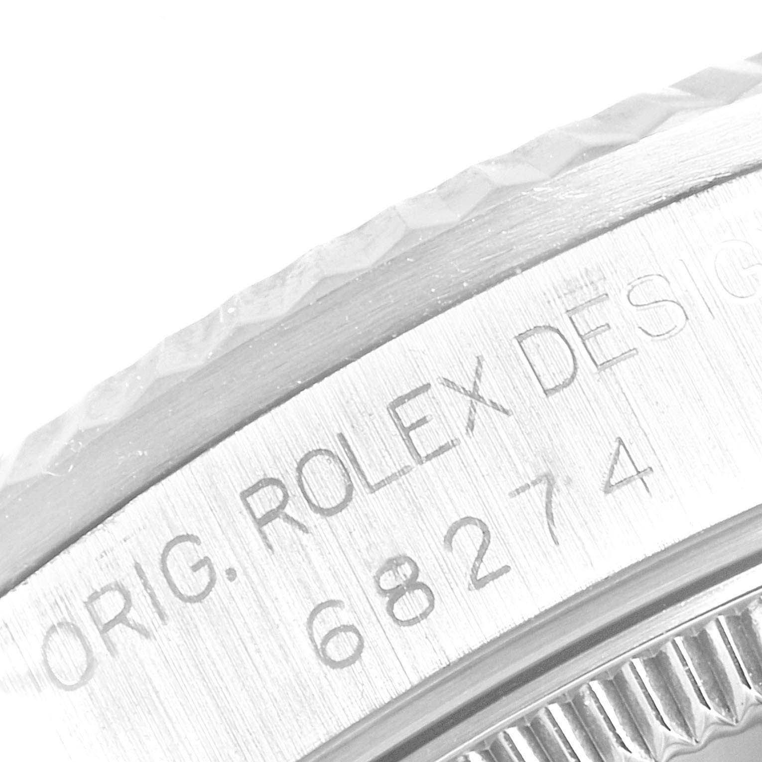 The image shows a close-up angle of a Mid-Size Rolex watch model featuring its engraved bezel and serial number.