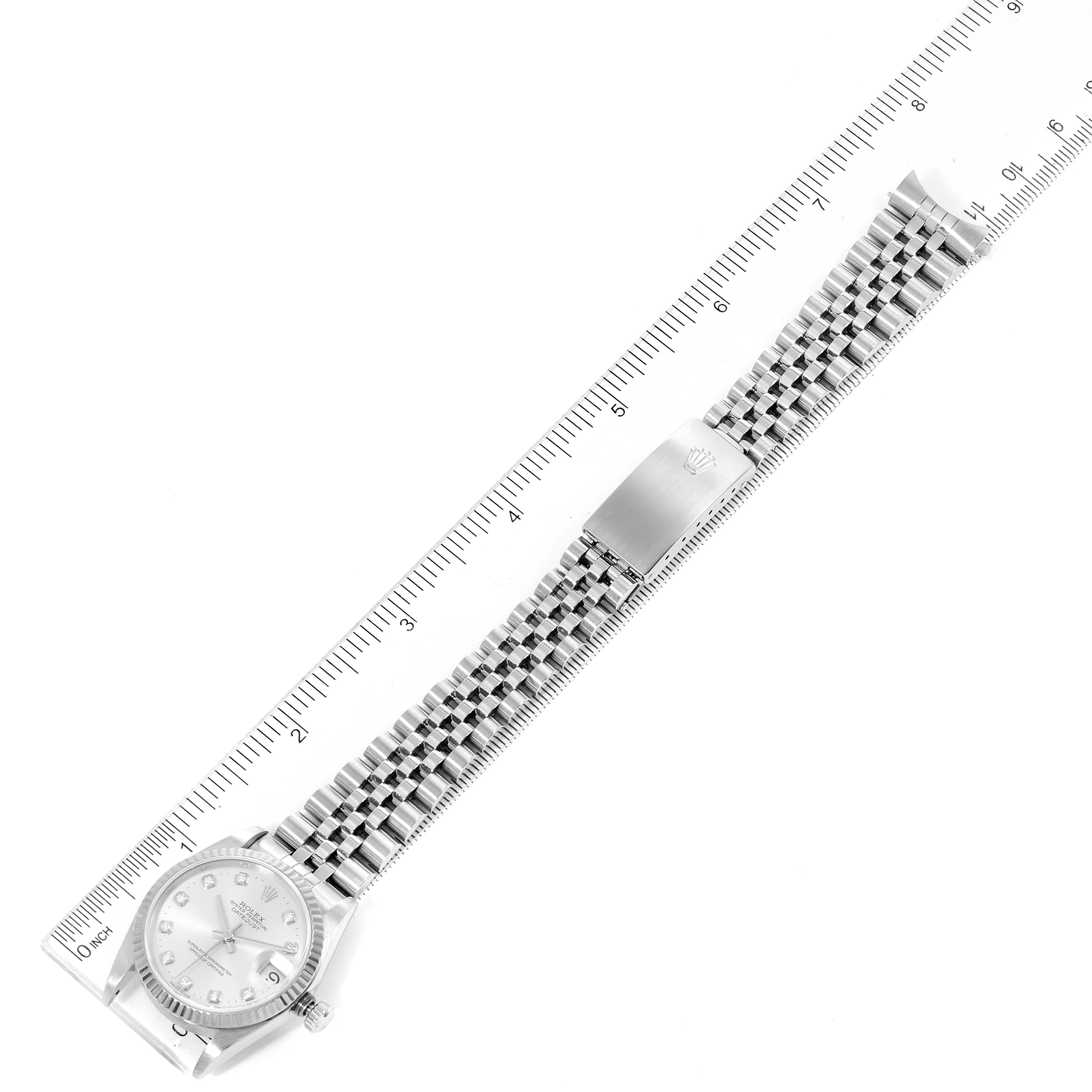 The image shows a top-down view of a Rolex Mid-Size 68274 Women
s Stainless Steel Silver Dial 68274 Women
s Stainless Steel Silver Dial watch and its stainless steel bracelet, with a ruler for scale.