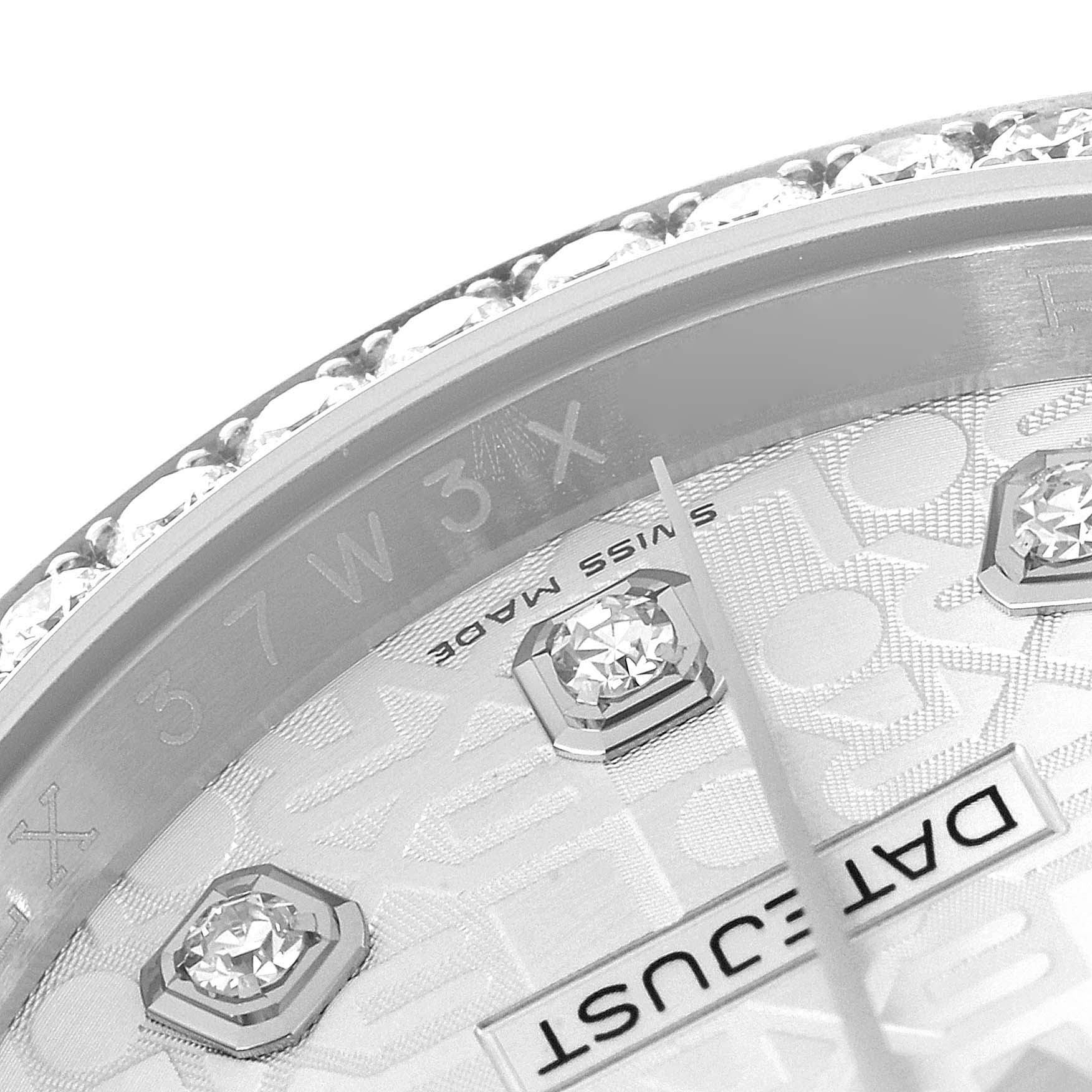 The image shows a close-up of a Rolex Datejust 116244 Men's Stainless Steel Silver Dial 116244 Men's Stainless Steel Silver Dial watch's dial, specifically the edge, diamonds, and hand with part of the Datejust logo.