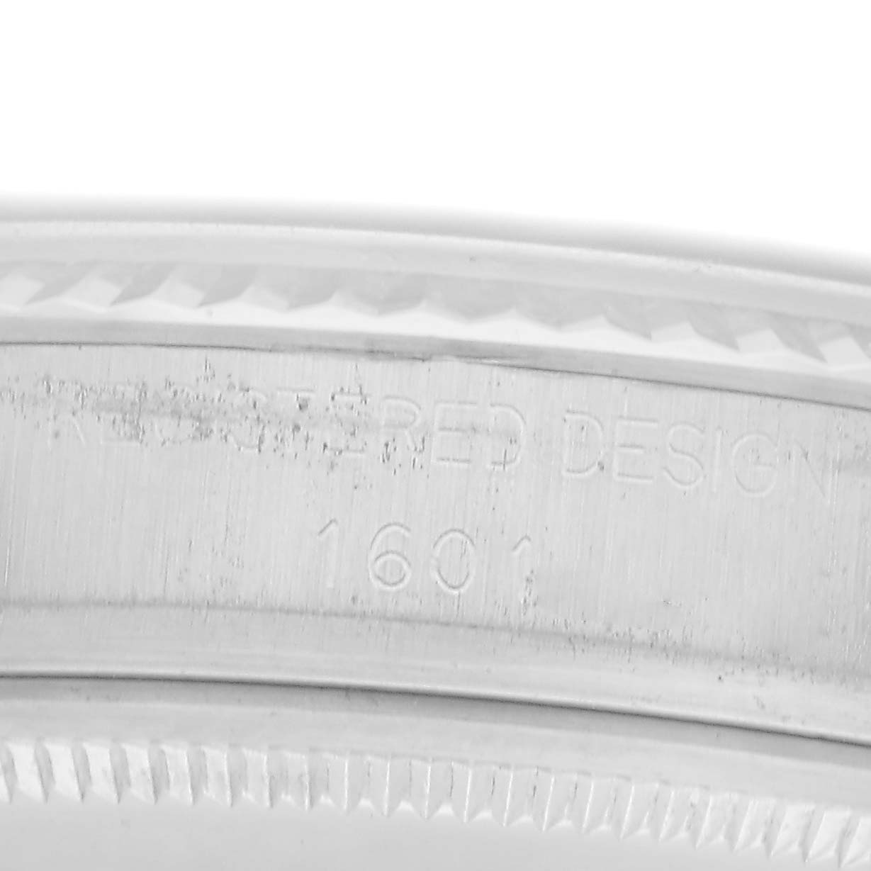 The image shows the engraved side detail of the case back for a Rolex Vintage Collection model, model number 1601, focusing on the serial number and design text.