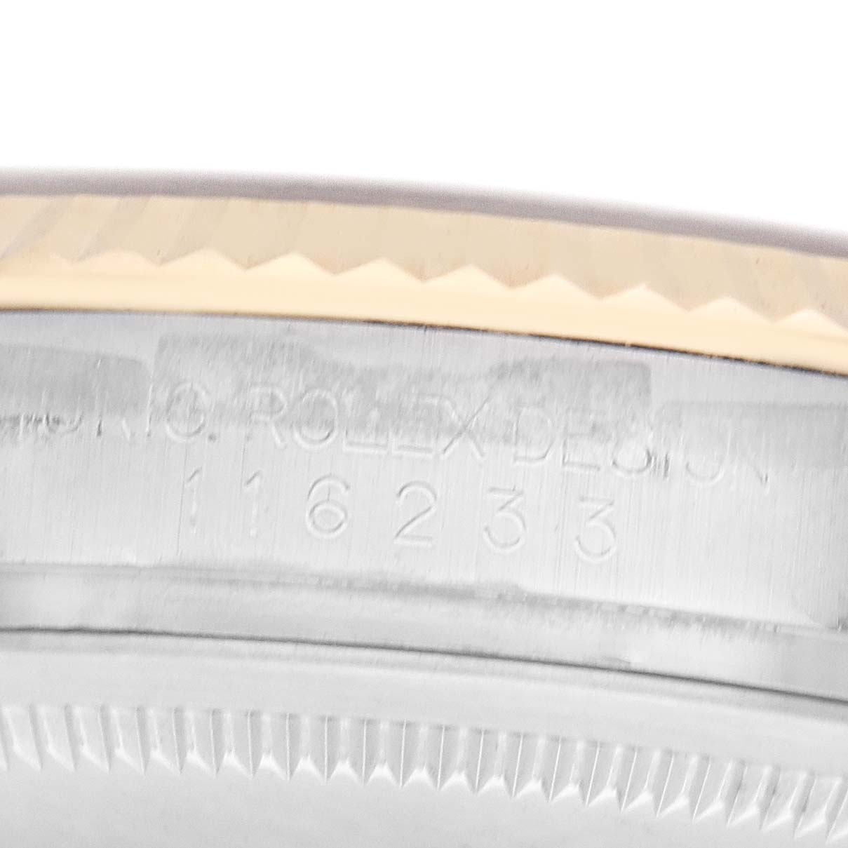 This image shows a close-up of the engraving on the side of a Rolex Datejust model 116233 men
s watch, focusing on the case edge and model number.