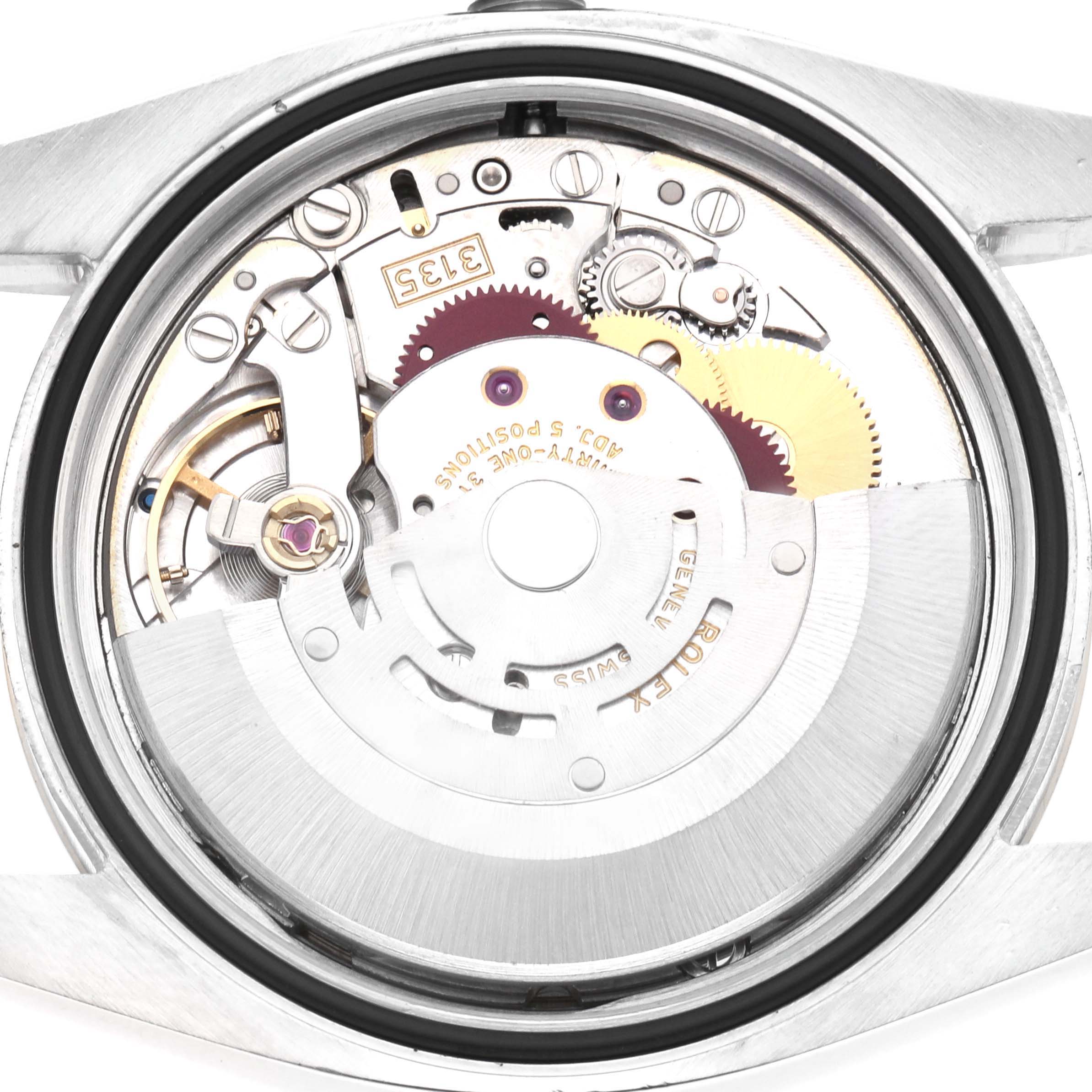 The image shows the movement of a Rolex Datejust Model 116233 from a rear angle, highlighting gears, the rotor, and intricate mechanical components.