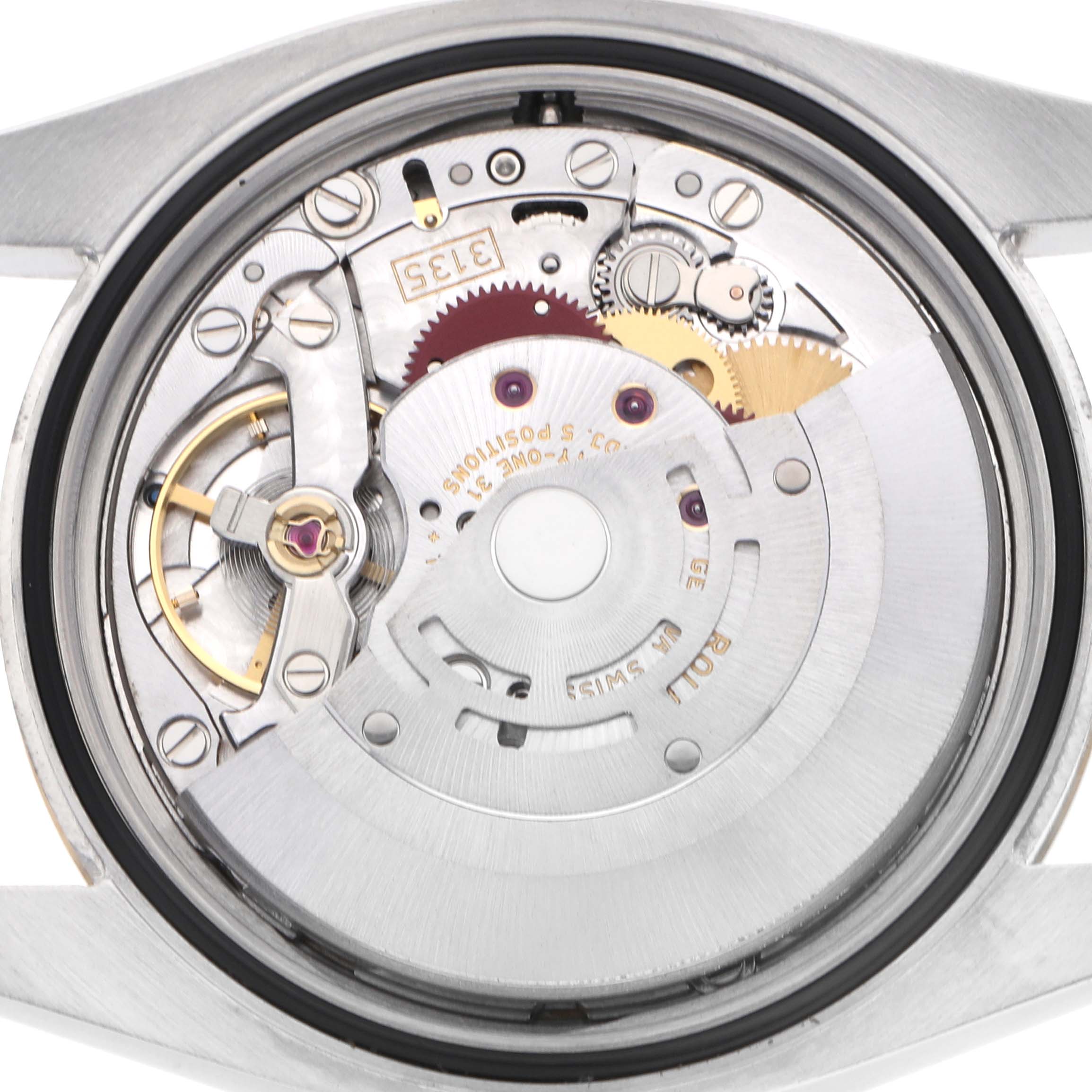 The image shows the movement of a Rolex Datejust model 116233 watch from a top-down angle, highlighting its gears and mechanical components.