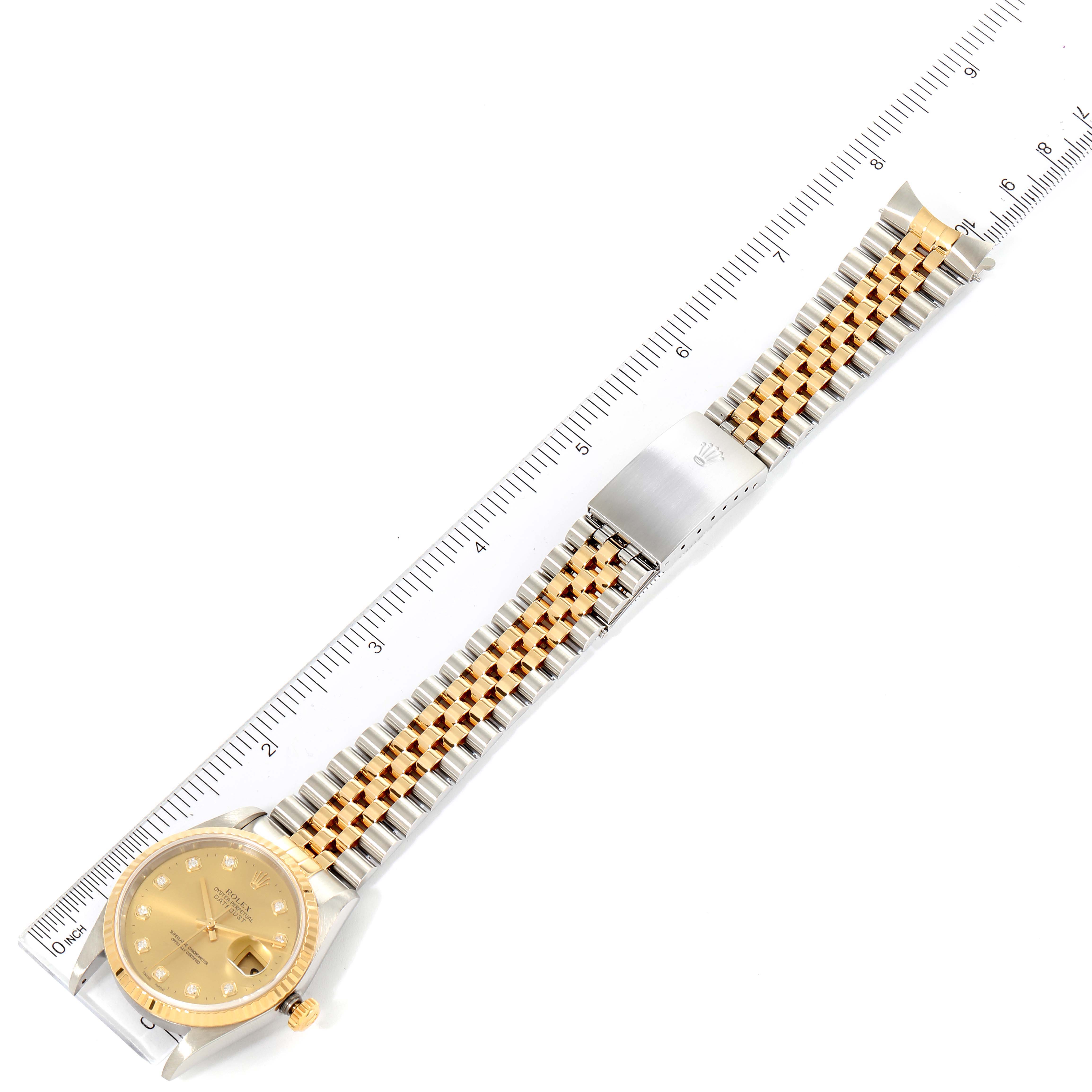 The Rolex Datejust 16233 Men's Steel and Gold (two tone) Champagne Dial 16233 Men's Steel and Gold (two tone) Champagne Dial watch is shown from an overhead angle displaying the dial, case, and segmented bracelet next to a ruler.