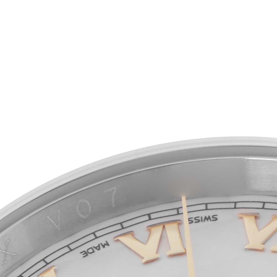 The image shows a close-up of a Rolex Datejust model 116233, detailing part of the dial with Roman numerals and the edge of the watch case.