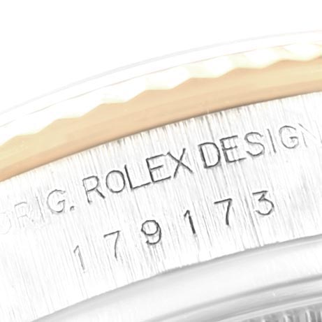 The image shows an angled close-up of the bezel and case side of a Rolex Datejust 179173 Women's Steel and Gold (two tone) Red Dial 179173 Women's Steel and Gold (two tone) Red Dial watch, focusing on the engraved "ROLEX DESIGN" and reference number.