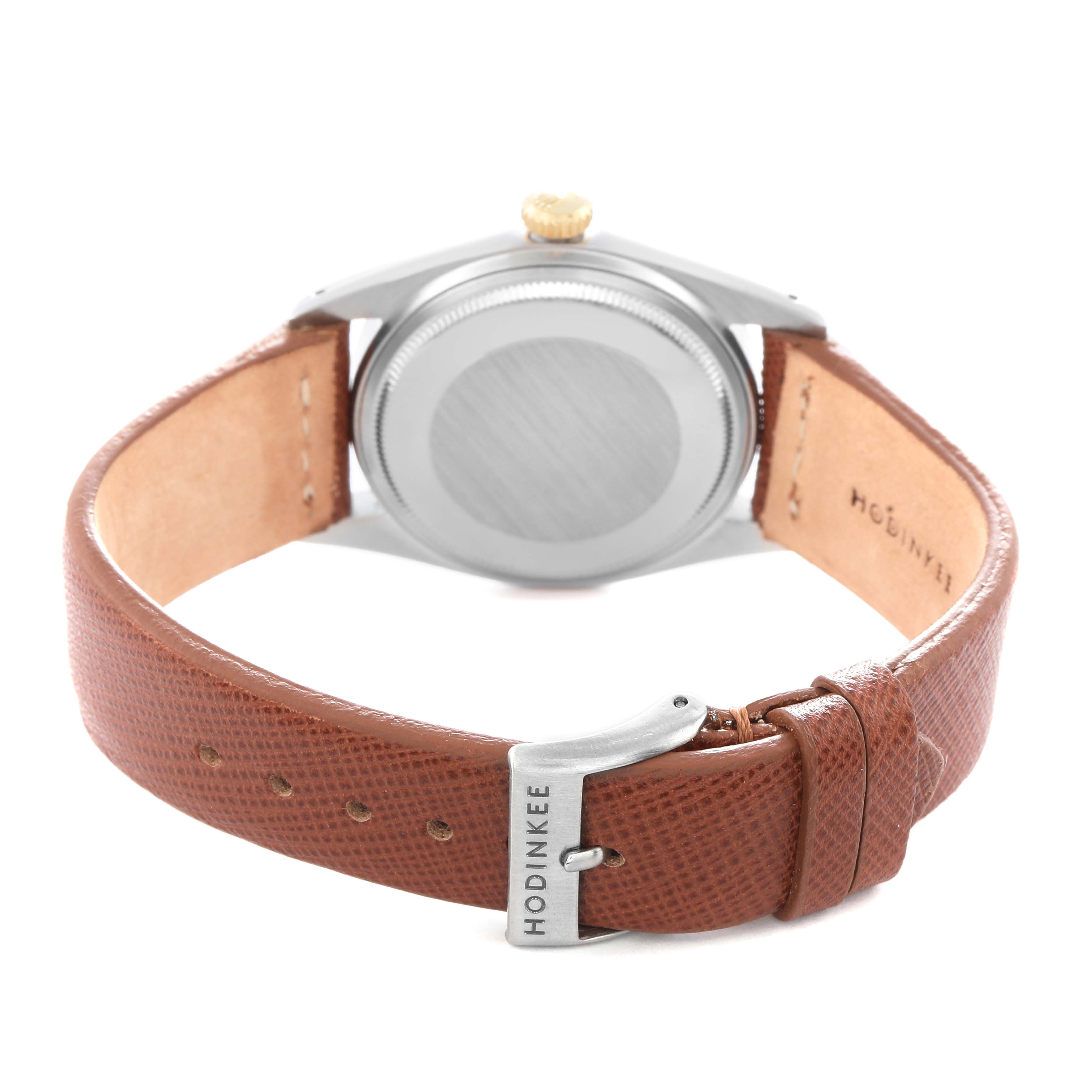 The image shows the back of a Rolex Datejust model 1601 men
s watch, featuring its case back, brown leather strap, and clasp.