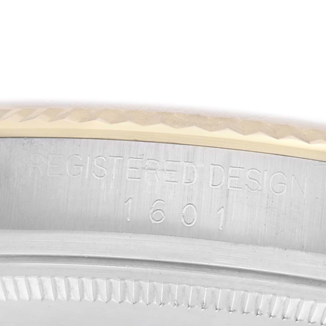 The image shows a close-up of the side of a Rolex Datejust watch, model number 1601, focusing on the engraved "REGISTERED DESIGN 1601" text on the case.