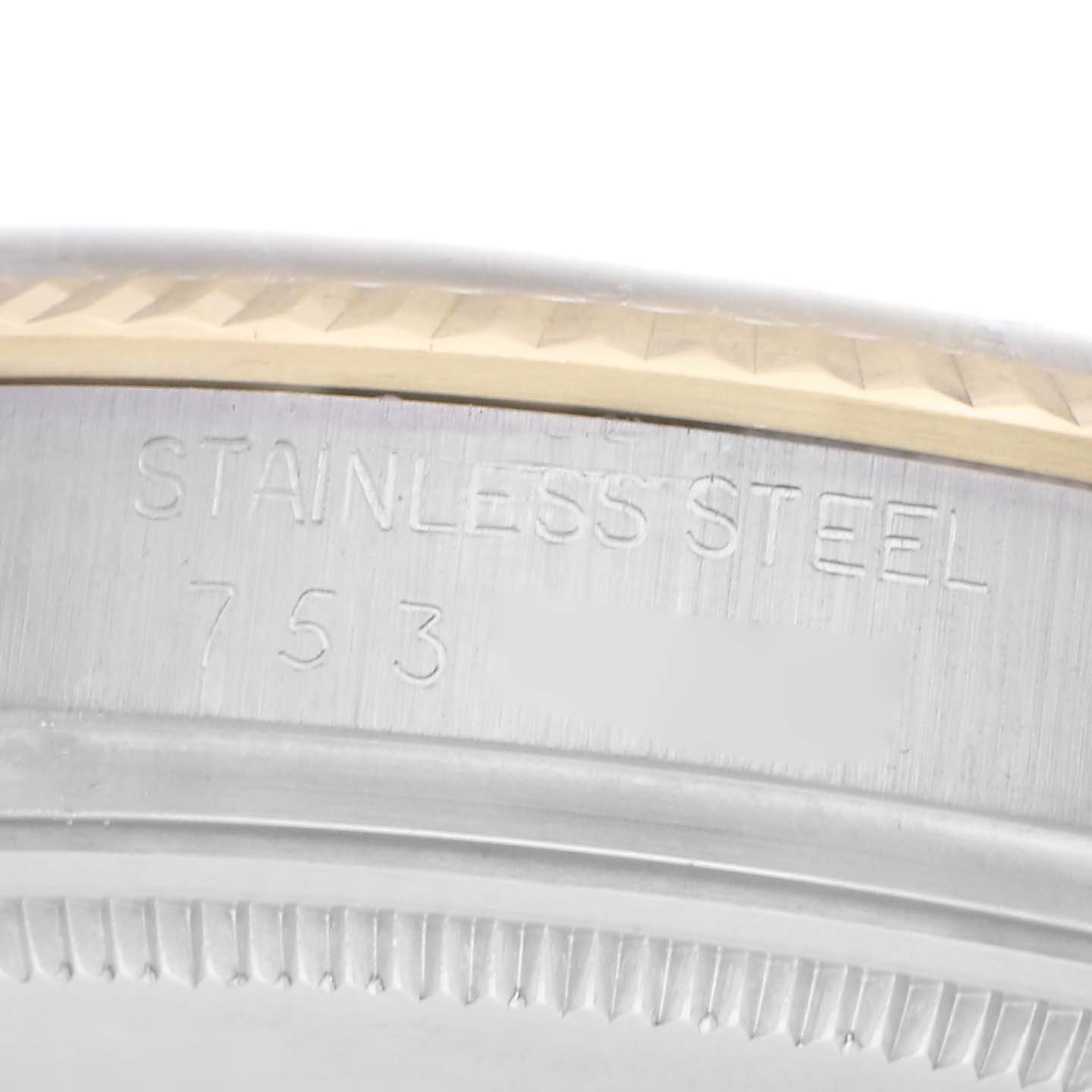 The image shows a close-up view of the watch
s fluted bezel and the stamped text indicating "STAINLESS STEEL" on the Rolex Datejust 16013.