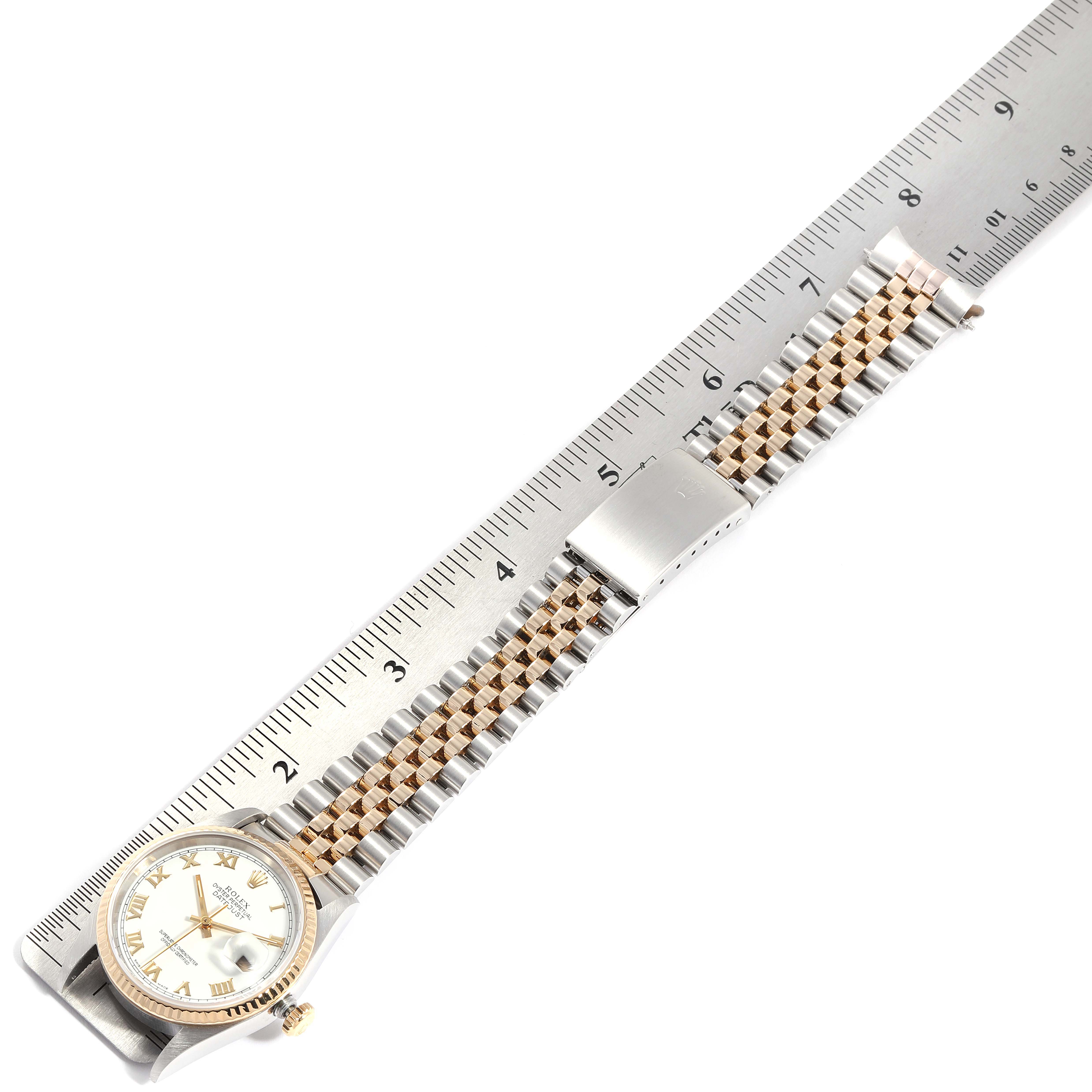 This image shows a Rolex Datejust 16233 Men
s Steel and Gold (two tone) White Dial 16233 Men
s Steel and Gold (two tone) White Dial model watch placed flat alongside a ruler, displaying the watch face and the full bracelet.