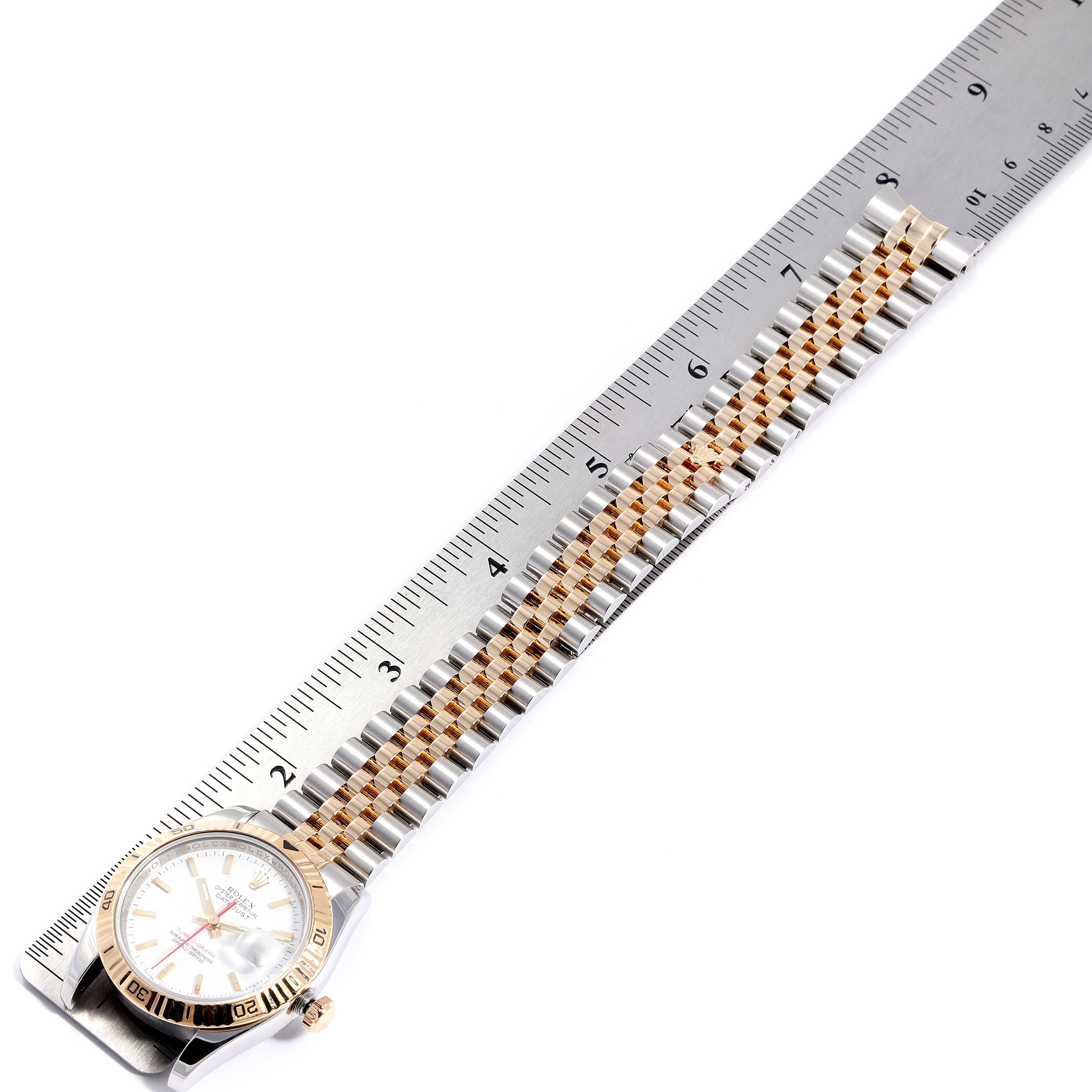 The Rolex Turn-o-Graph 116263 Men's Steel and Gold (two tone) White Dial 116263 Men's Steel and Gold (two tone) White Dial watch is shown from an overhead angle, displaying the face and the entire bracelet alongside a ruler for scale.