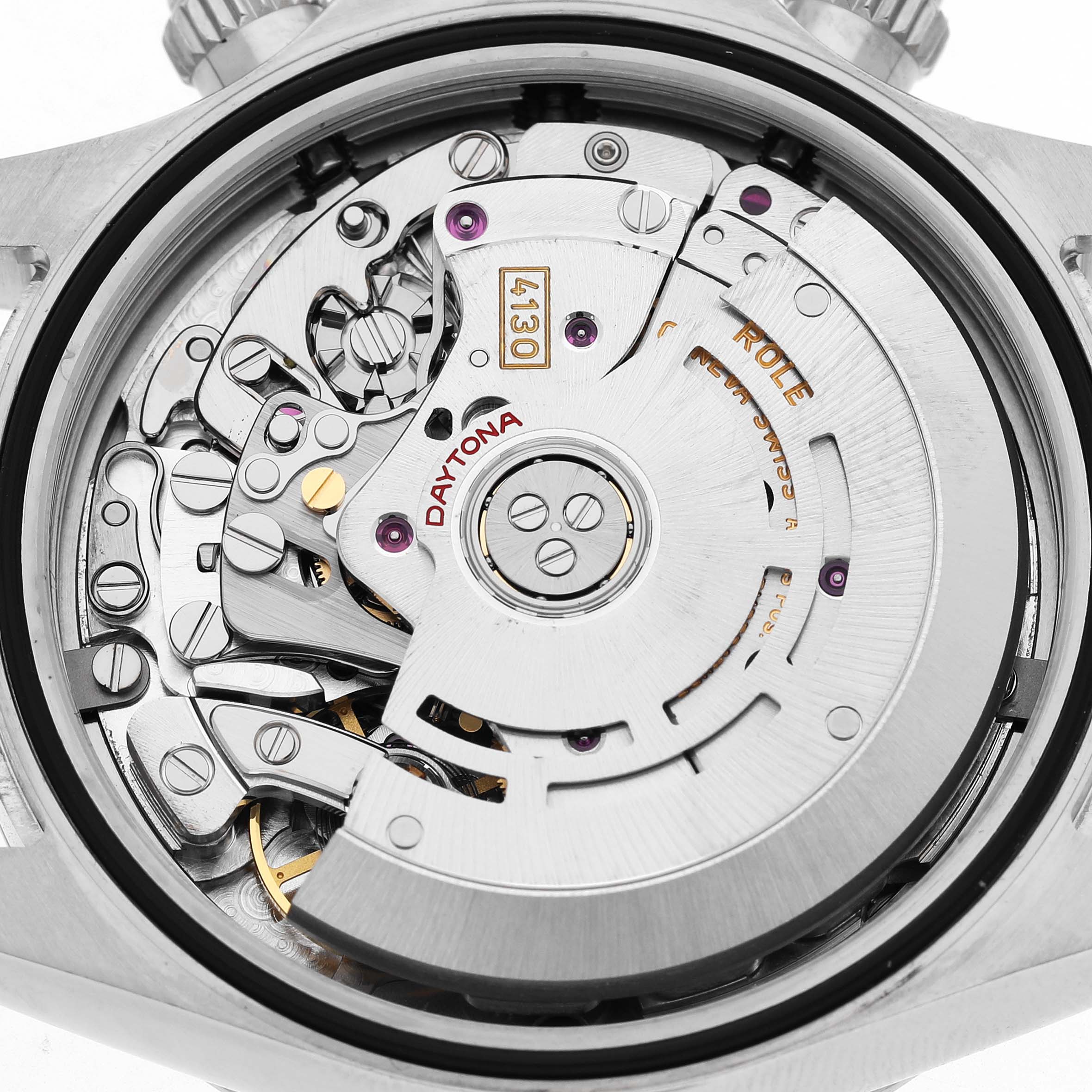 The image shows the movement from the back of a Rolex Daytona 116520 Men's Stainless Steel White Dial, highlighting gears and components.