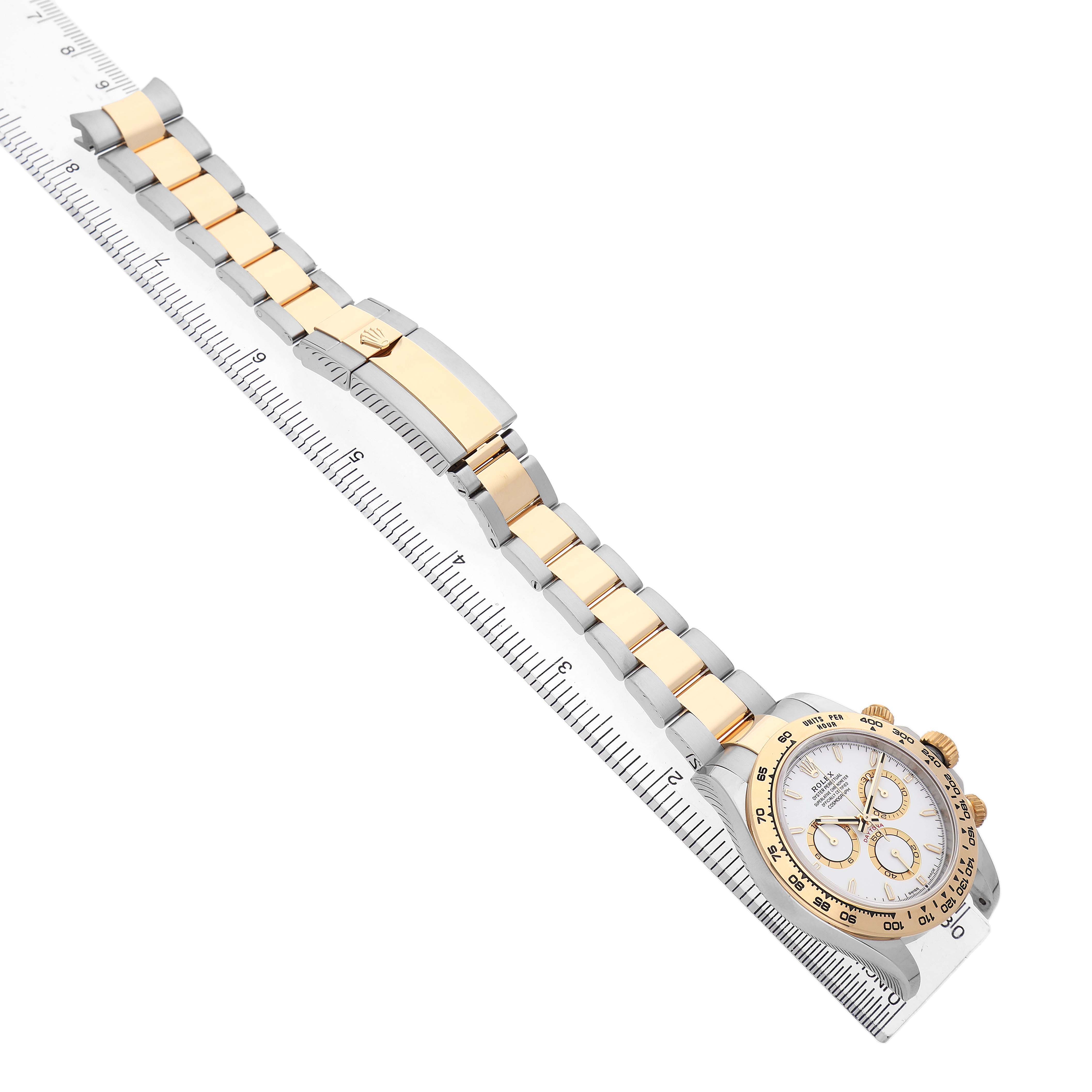 The Rolex Daytona 126503 Men's Steel and Gold (two tone) White Dial watch is shown at an angle displaying its full strap, clasp, and face alongside a ruler for size reference.