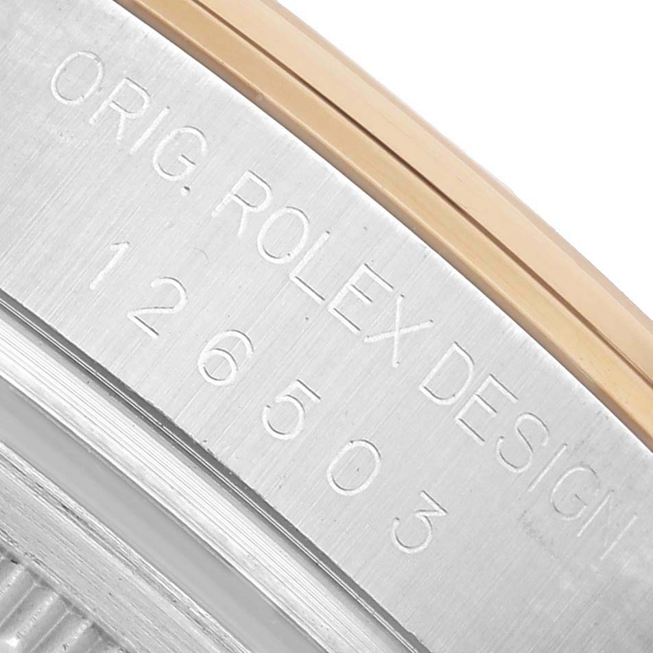 The image shows a close-up of the Rolex Daytona 126503 Men's Steel and Gold (two tone) White Dial model's case side, featuring engraved branding and design numbers.