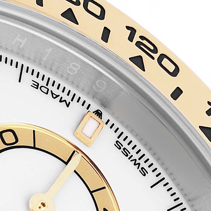 The image shows a close-up of the Rolex Daytona 126503 Men's Steel and Gold (two tone) White Dial's bezel, dial, and minute hand at an oblique angle.