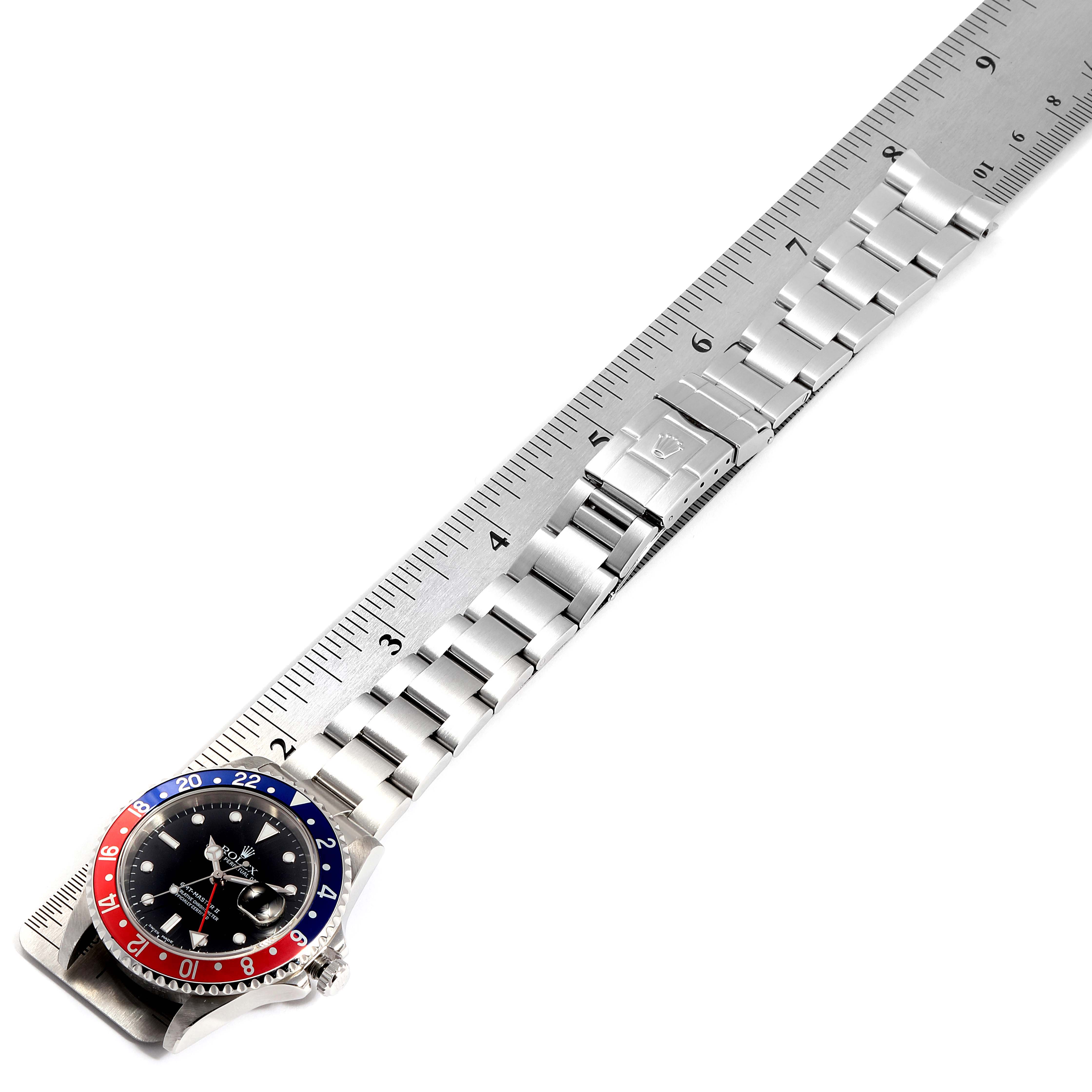 The image shows a Rolex GMT-Master 16710 Men
s Stainless Steel Black Dial 16710 Men
s Stainless Steel Black Dial watch laid flat, with the bracelet and bezel visible, next to a ruler for size reference.