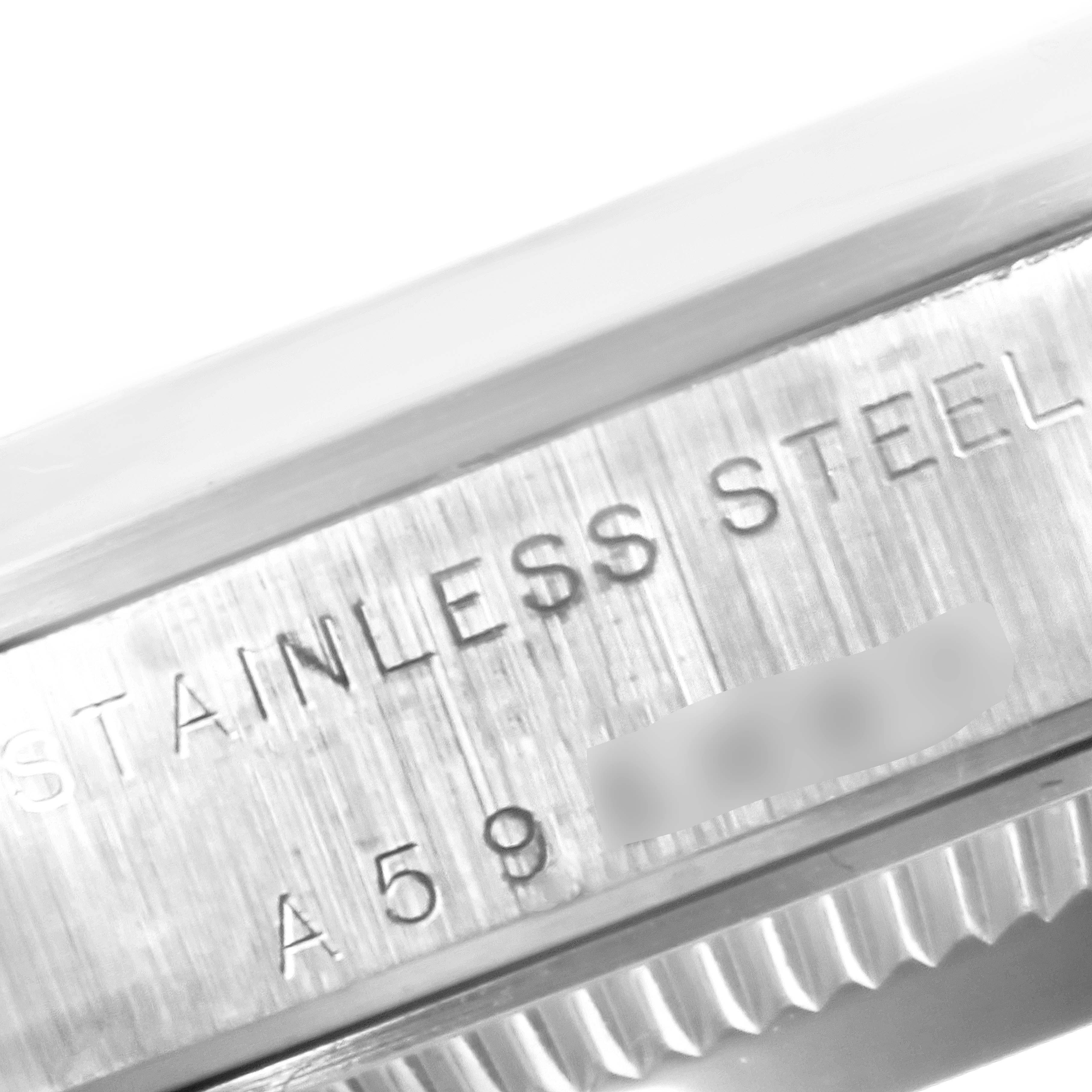 The image shows an angled close-up of the serial number and "STAINLESS STEEL" engraving on the side of a Rolex Mid-Size 77080 Women
s Stainless Steel White Dial 77080 Women
s Stainless Steel White Dial watch case.