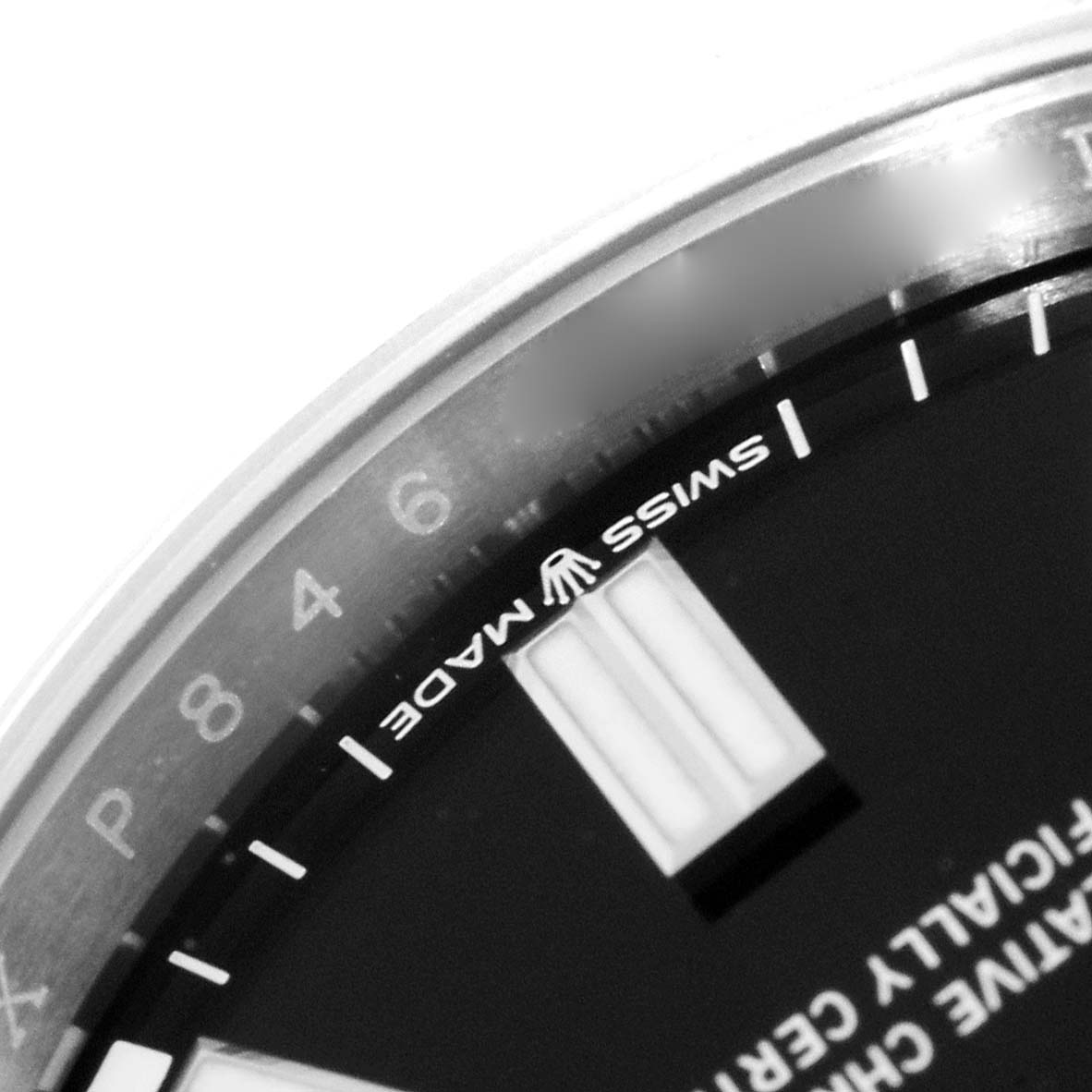 This close-up image shows the edge of the dial and part of the bezel of a Rolex Oyster Perpetual 126000 Men's Stainless Steel Black Dial 126000 Men's Stainless Steel Black Dial watch.