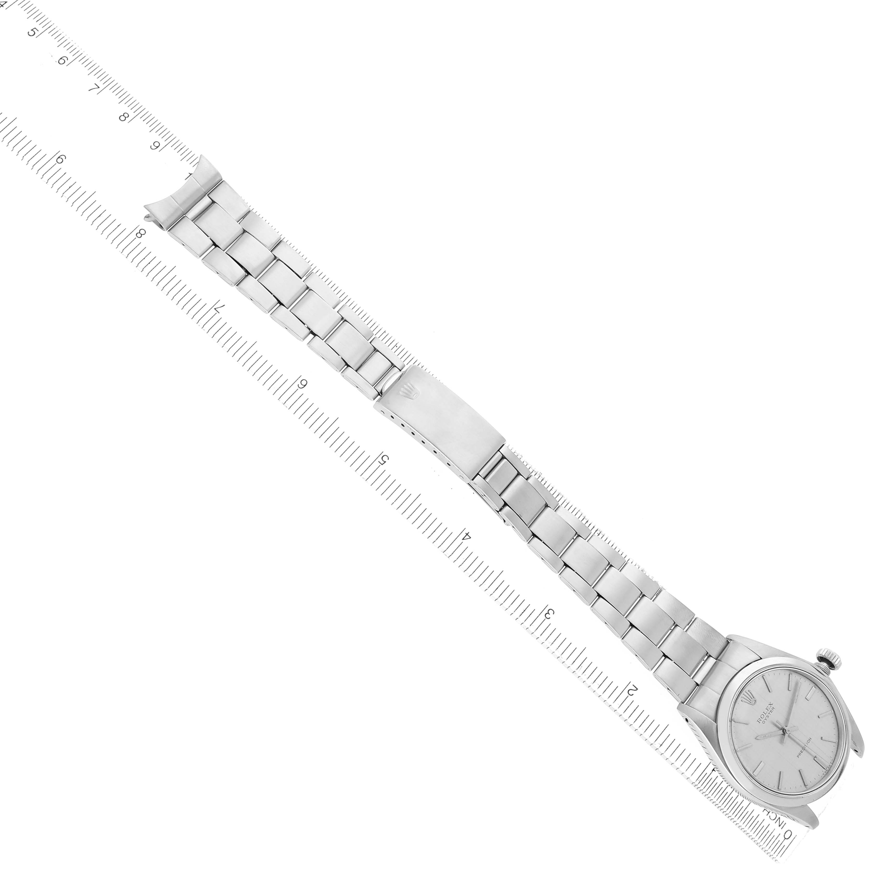 The Rolex Vintage Collection model 6426 men
s watch is shown from a top-down angle, displaying the full watch face and stainless steel bracelet alongside a ruler.