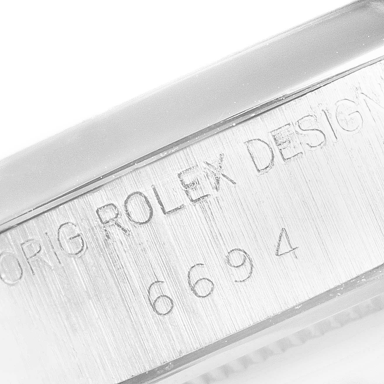 The image shows a close-up of the side engraving on a Rolex Vintage Collection 6694 Men's Stainless Steel Silver Dial 6694 Men's Stainless Steel Silver Dial model, displaying "ORIG ROLEX DESIGN 6694".