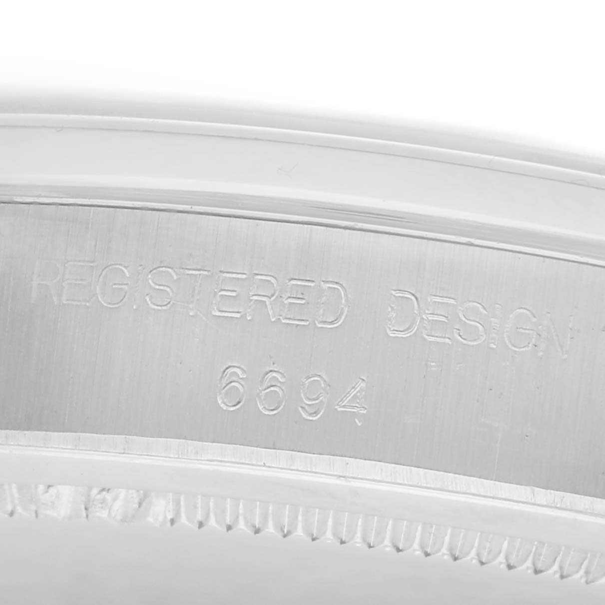 The image shows a close-up of the engraved inner case of the Rolex Vintage Collection, model number 6694, highlighting the "REGISTERED DESIGN" inscription.