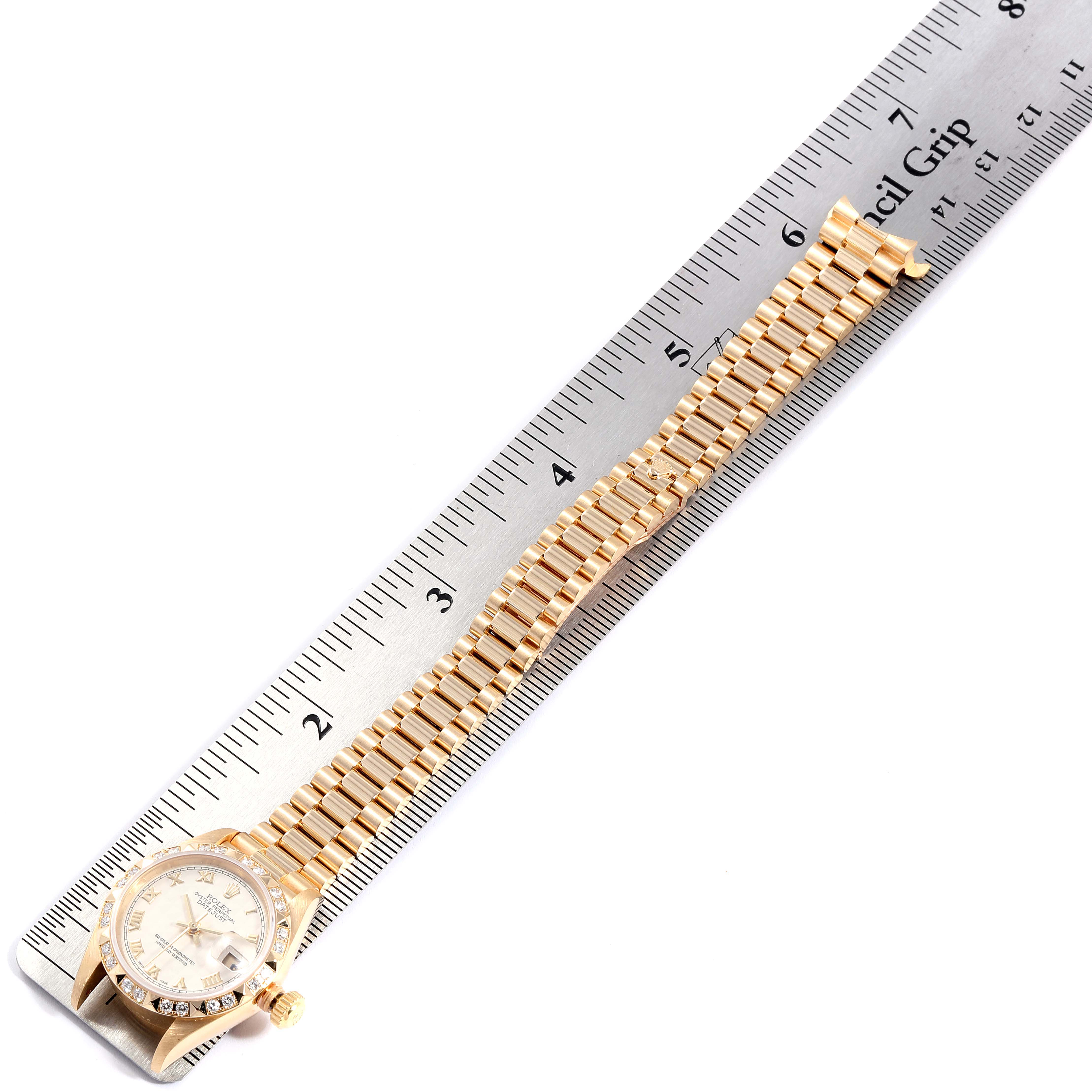 The image shows a Rolex President 79258 Women's Yellow Gold Beige Dial 79258 Women's Yellow Gold Beige Dial model watch, focusing on the full-length gold bracelet and the watch face, alongside a ruler for measurement.