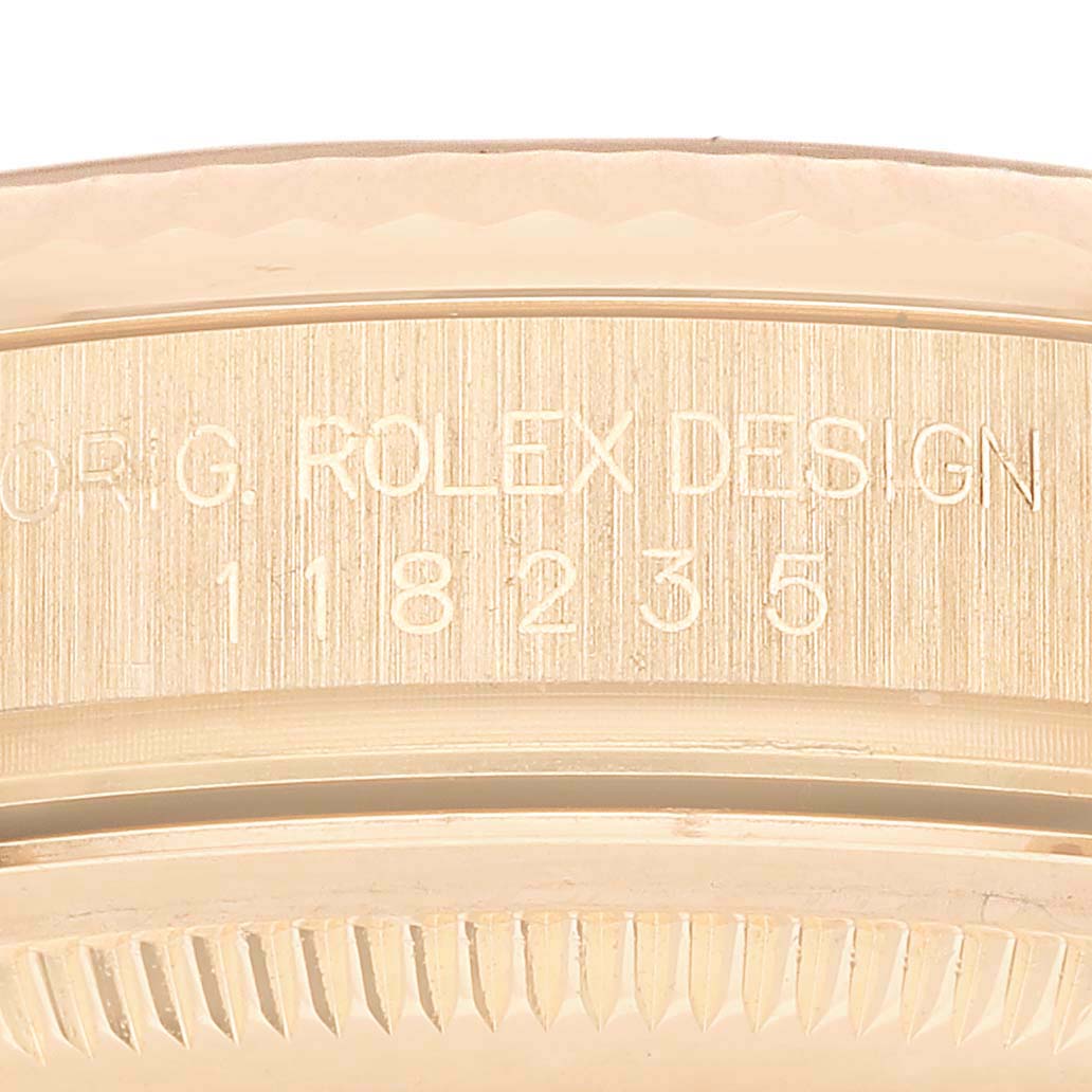 The image shows a close-up of the side of a Rolex President 118235 Men's Rose Gold Pink Dial model watch, displaying the engraved design and model number.