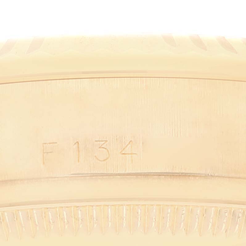 This image shows a partial close-up of the bezel and engraved serial number on a Rolex President 178278 Women's Yellow Gold Champagne Dial 178278 Women's Yellow Gold Champagne Dial model watch.