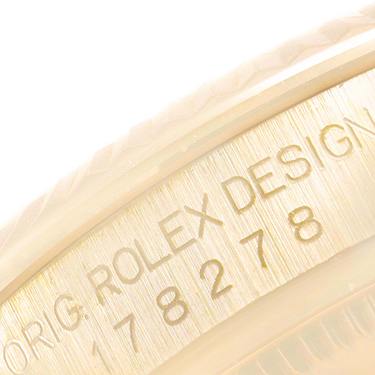 This image shows a close-up of the side of the Rolex President 178278 Women's Yellow Gold Champagne Dial 178278 Women's Yellow Gold Champagne Dial model, focusing on the engraved serial and model numbers.