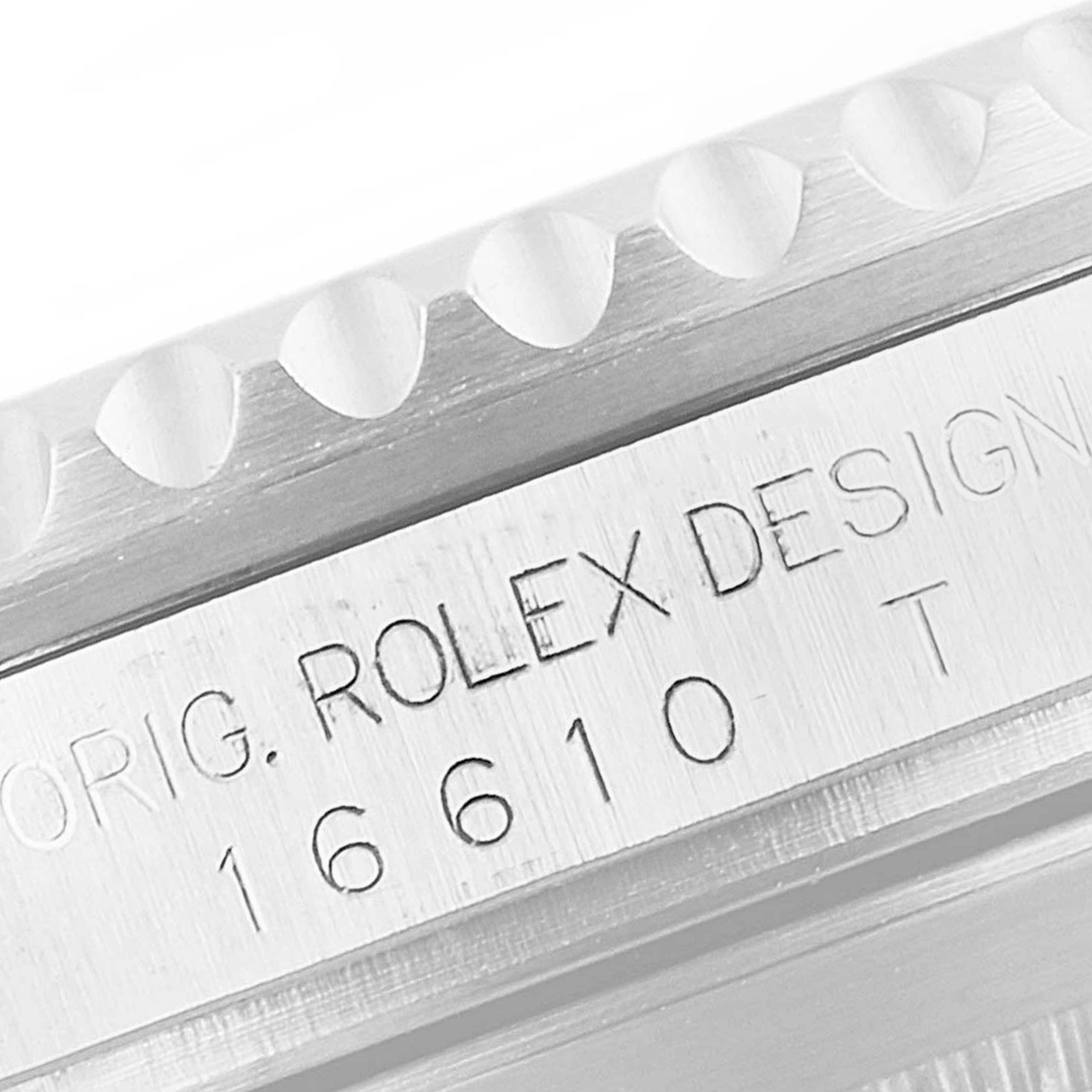 The image shows a close-up of the engraved side of a Rolex Submariner 16610 Men
s Stainless Steel Black Dial 16610 Men
s Stainless Steel Black Dial model 16610, highlighting the bezel and serial number.