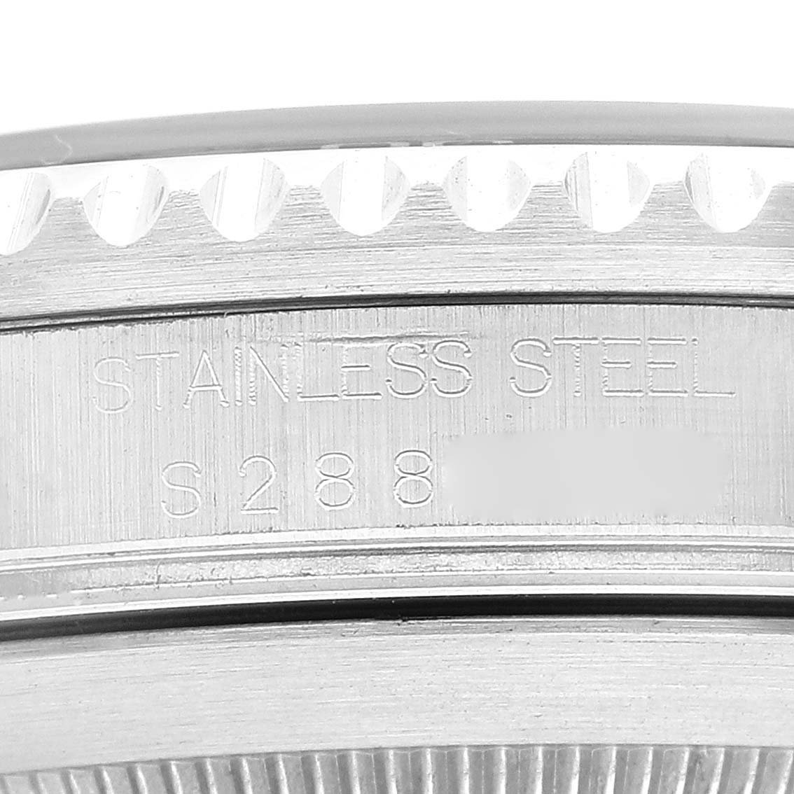 This image shows a close-up of the case back edge of a Rolex Submariner 16610 Men
s Stainless Steel Black Dial 16610 Men
s Stainless Steel Black Dial watch, displaying the stainless steel marking and part of the serial number.