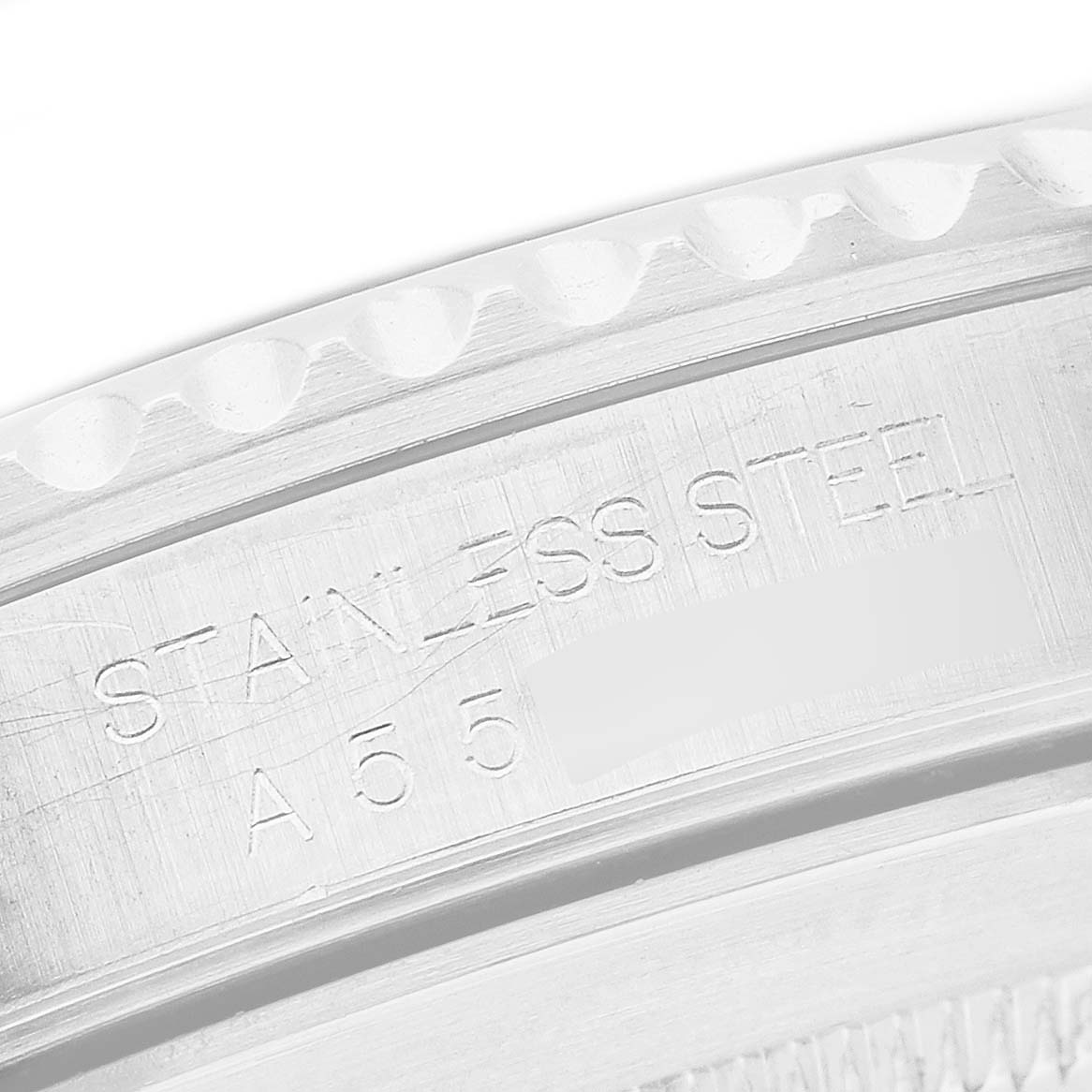 The image shows a close-up of the engraved edge of a Rolex Submariner 14060 Men's Stainless Steel Black Dial, highlighting the "STAINLESS STEEL" marking.