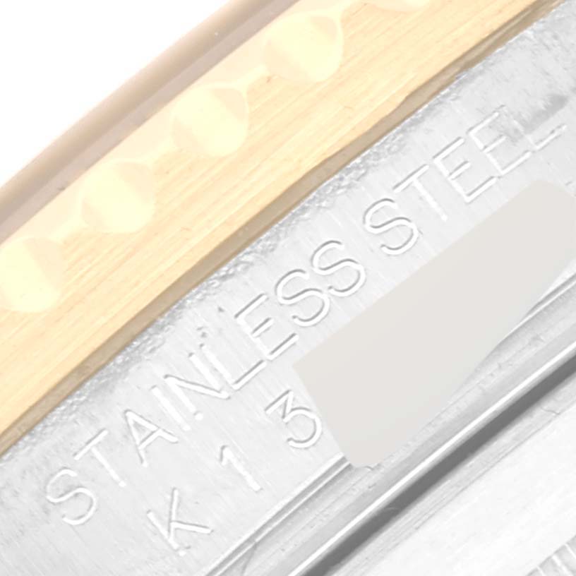 This image shows a macro shot of the side bezel and part of the inner case of a Rolex Submariner 16613 Men's Steel and Gold (two tone) Black Dial 16613 Men's Steel and Gold (two tone) Black Dial, highlighting the "STAINLESS STEEL" engraving.