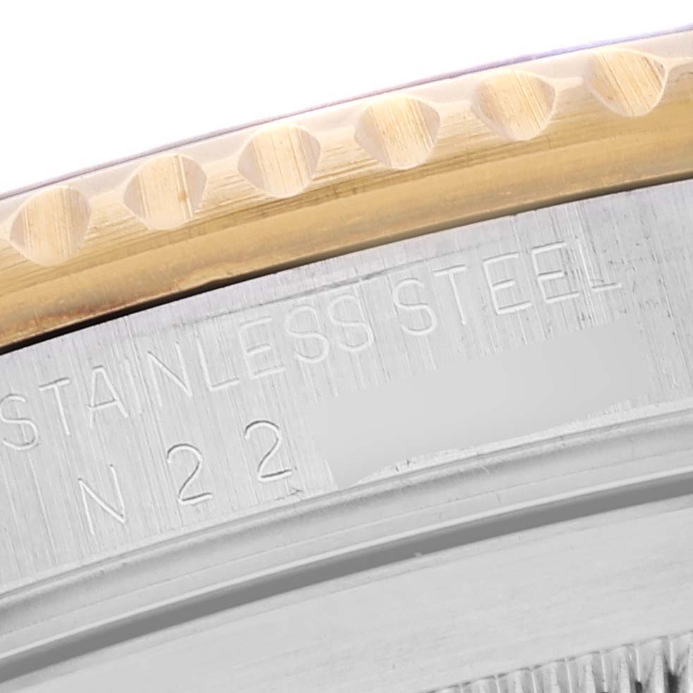 The image shows a close-up of the bezel and the engraved text on the back of a Rolex Submariner 16613 Men's Steel and Gold (two tone) Black Dial 16613 Men's Steel and Gold (two tone) Black Dial watch.