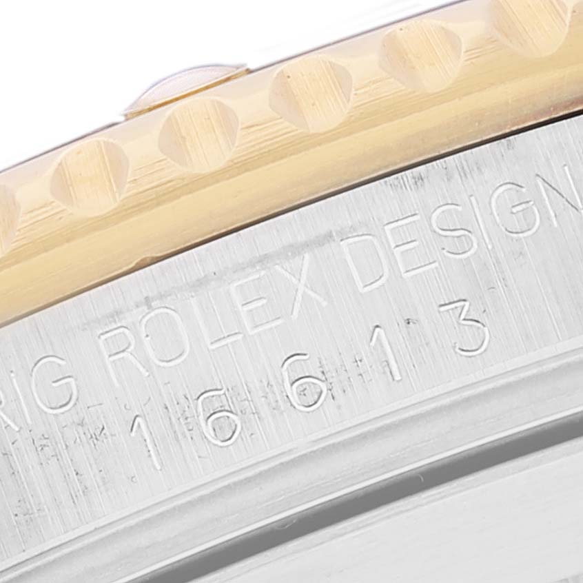 The image shows a close-up of the edging and model engraving of a Rolex Submariner 16613 Men's Steel and Gold (two tone) Black Dial 16613 Men's Steel and Gold (two tone) Black Dial watch.