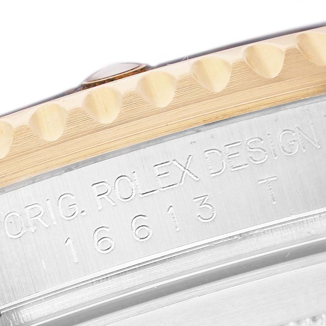 The image shows a close-up of the side of a Rolex Submariner 16613 Men's Steel and Gold (two tone) Black Dial watch, focusing on the bezel and engraved model number.